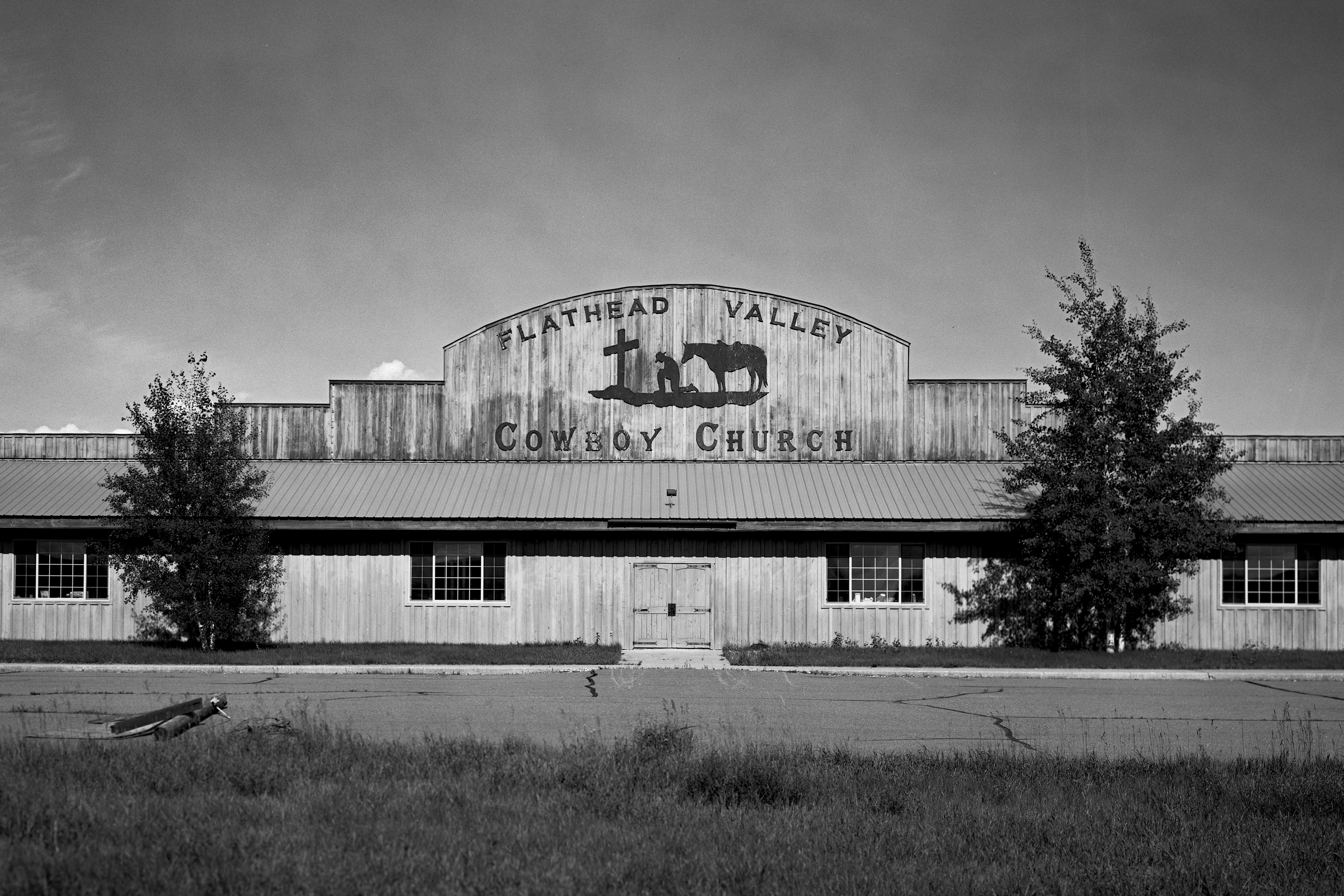 Flathead Valley Cowboy Church rustic wooden building with praying cowboy and horse silhouette
