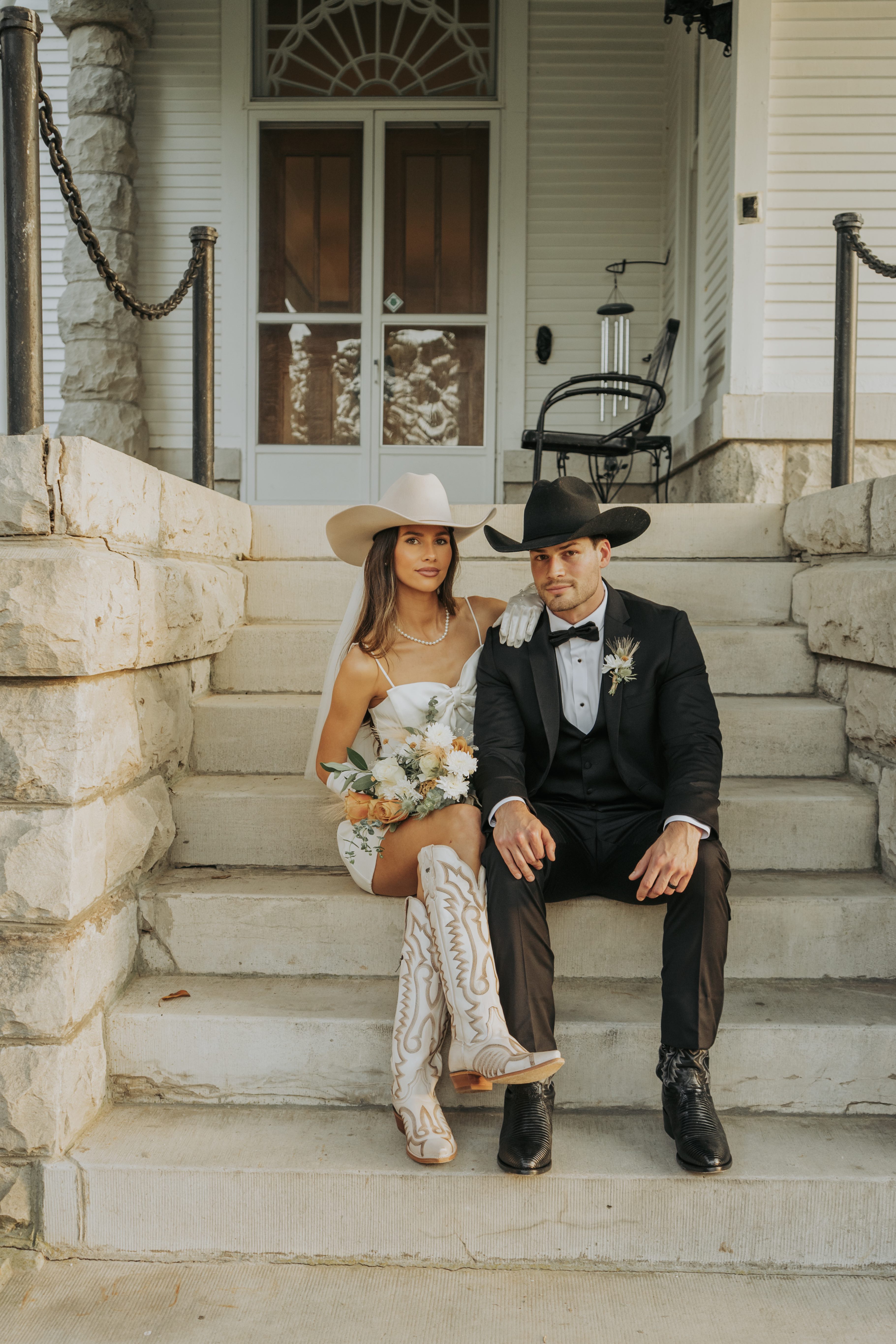 Bridal couple sitting on porch steps with cowboy boots