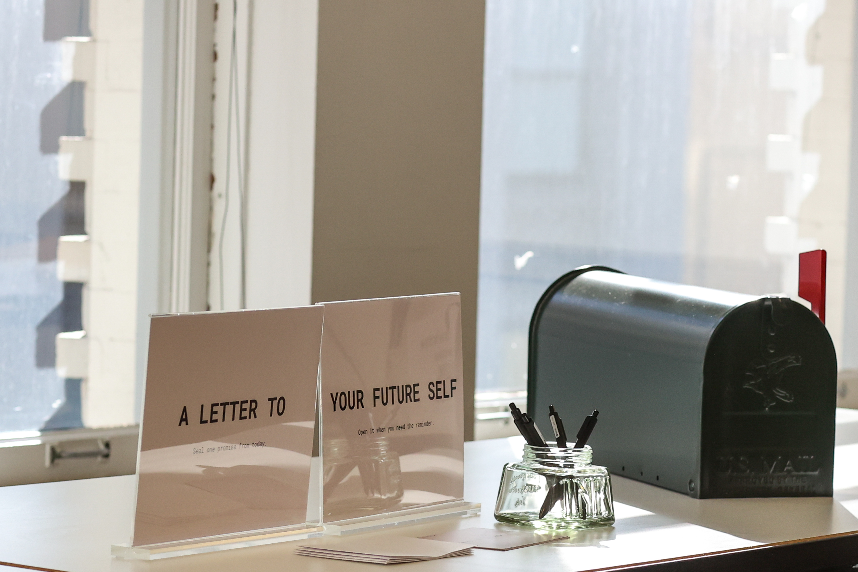 A Letter to Your Future Self station with acrylic signs, pens, and a black mailbox