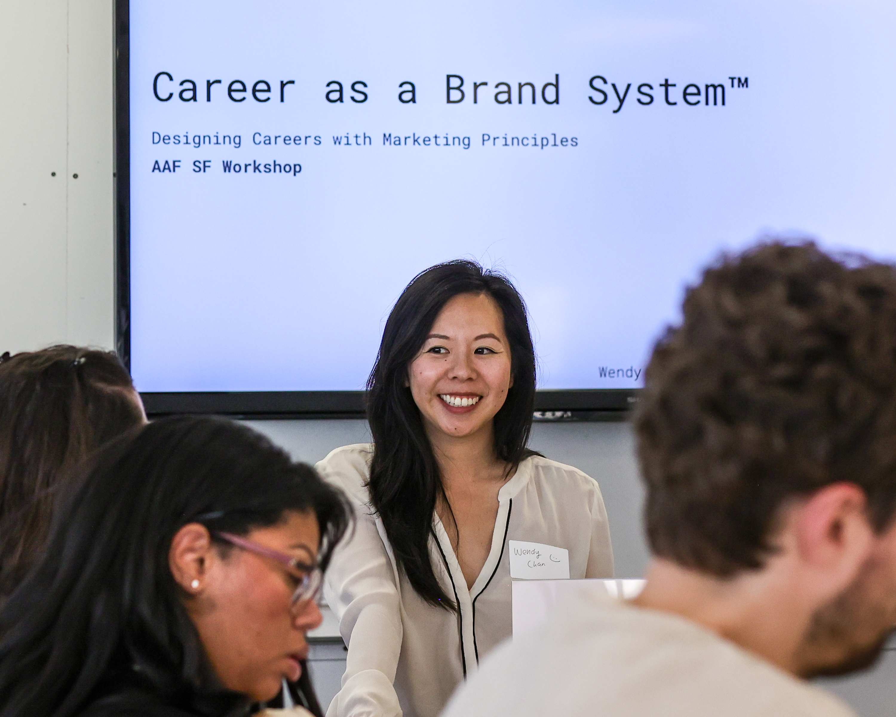 Wendy Chan smiling in front of the Career as a Brand System title slide during the AAF SF workshop