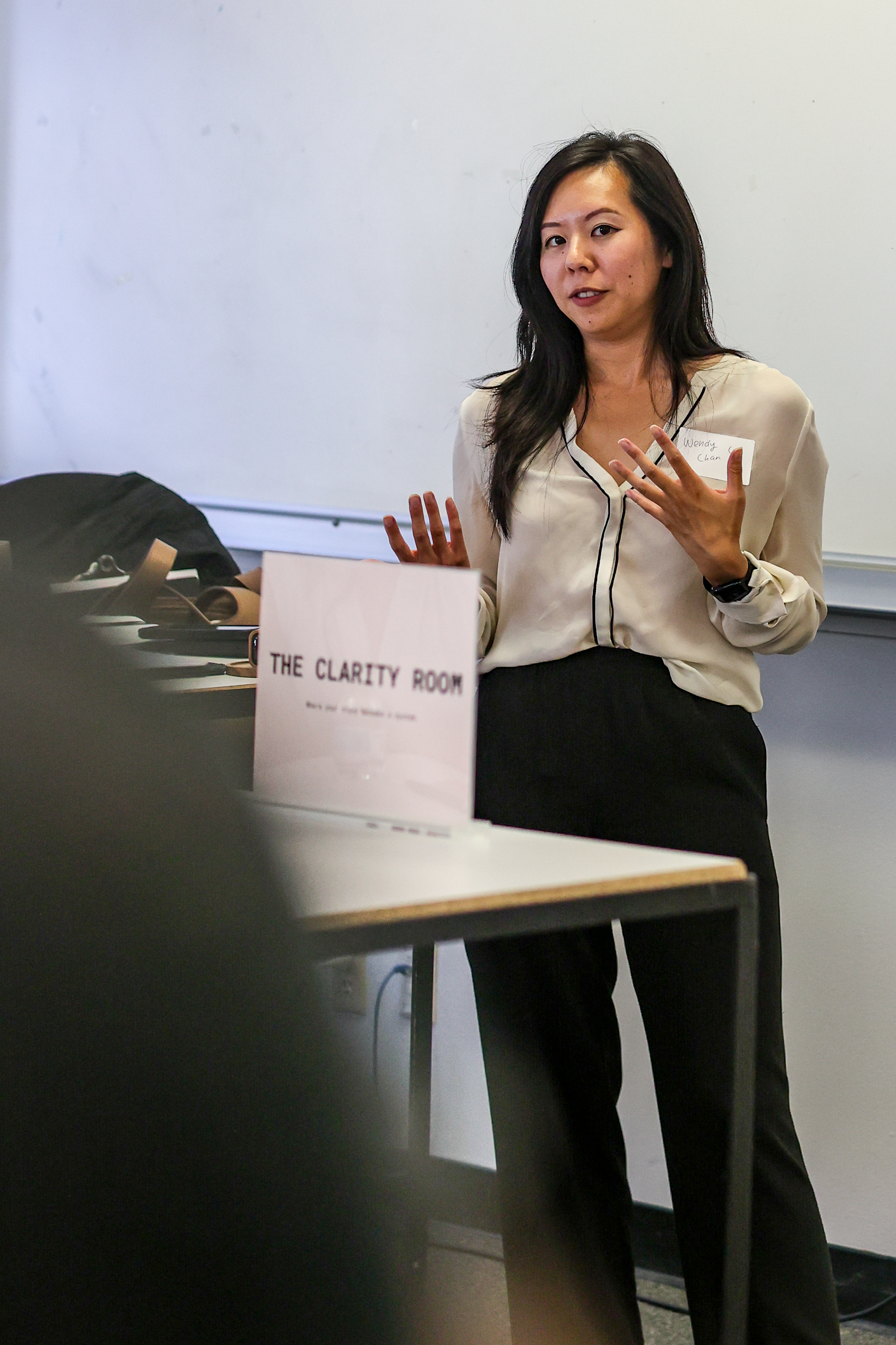 Wendy Chan speaking beside a sign reading The Clarity Room