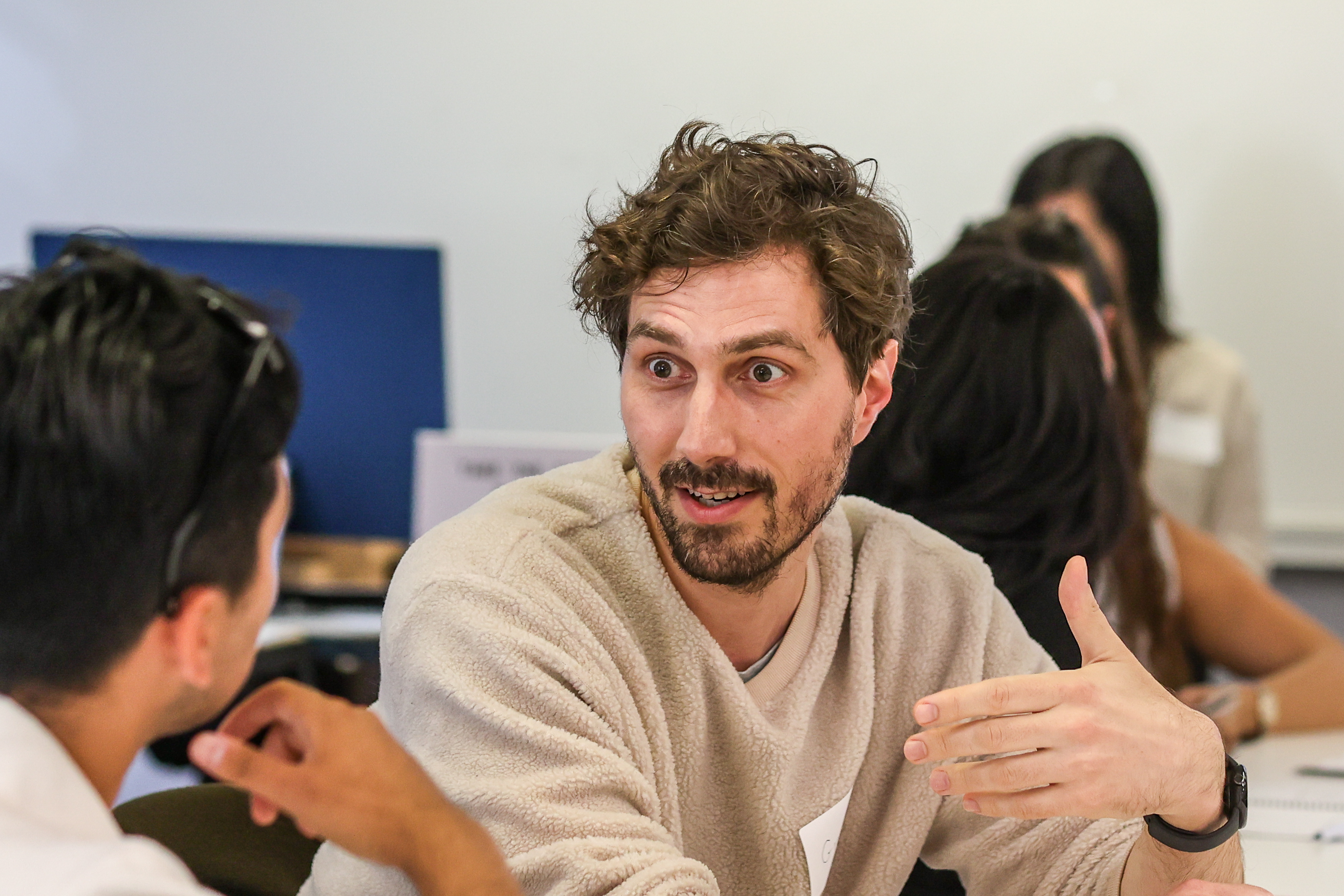 A participant gesturing animatedly during a paired discussion