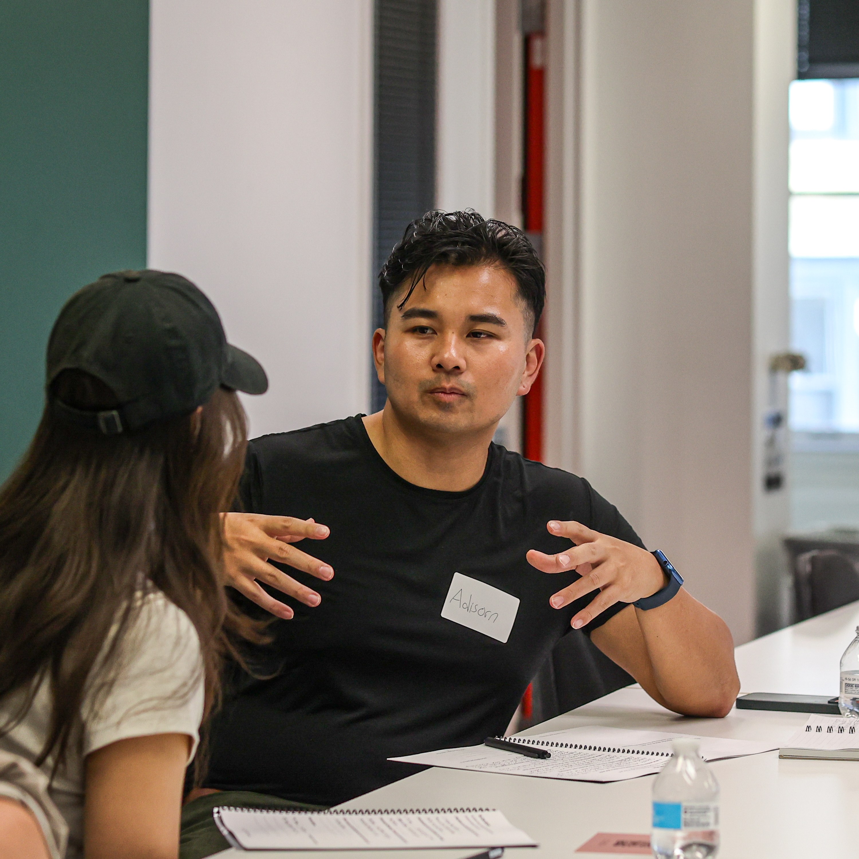 Attendee Adisorn explaining an idea with his hands during a discussion