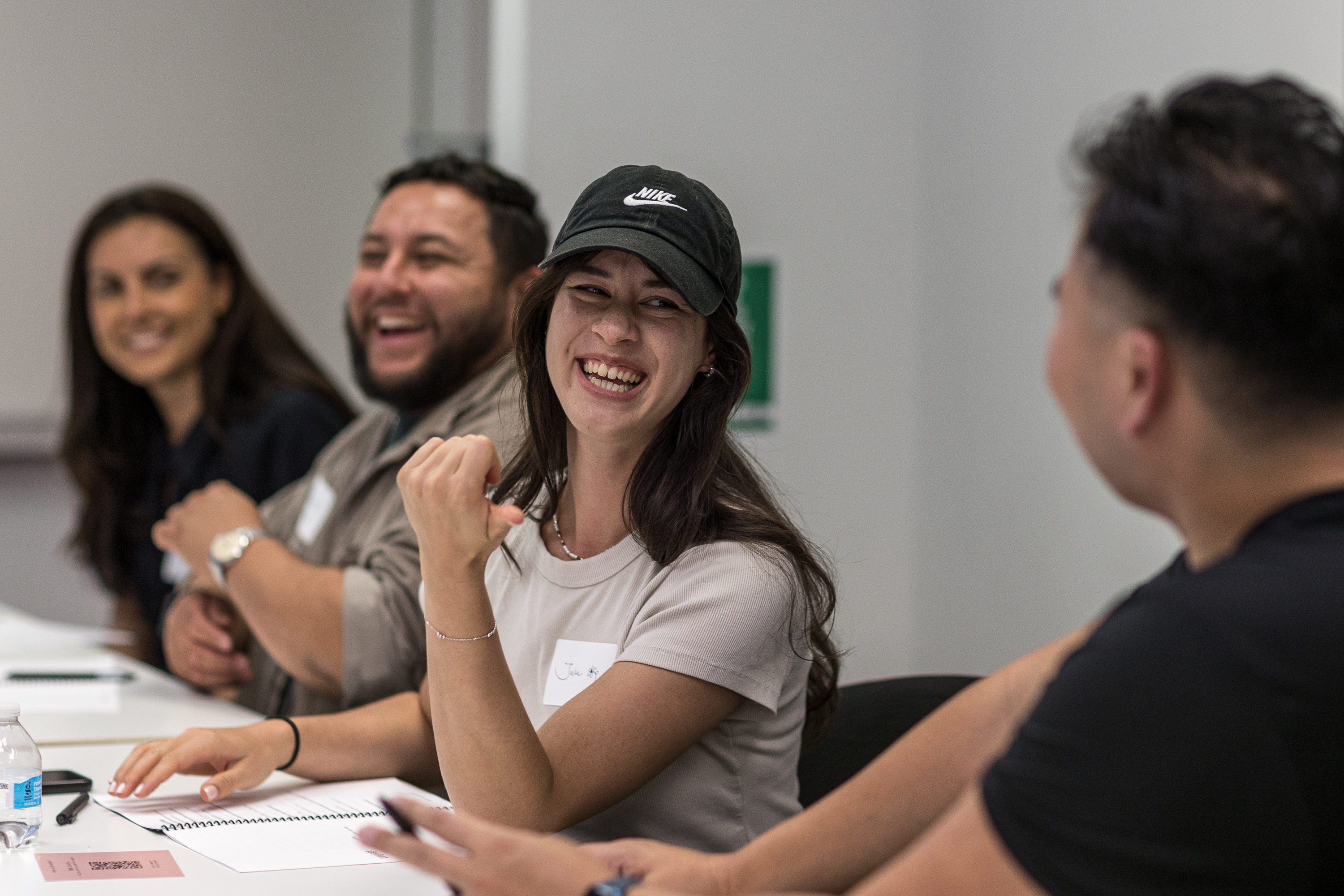 Participants laughing together during a partner conversation at the table