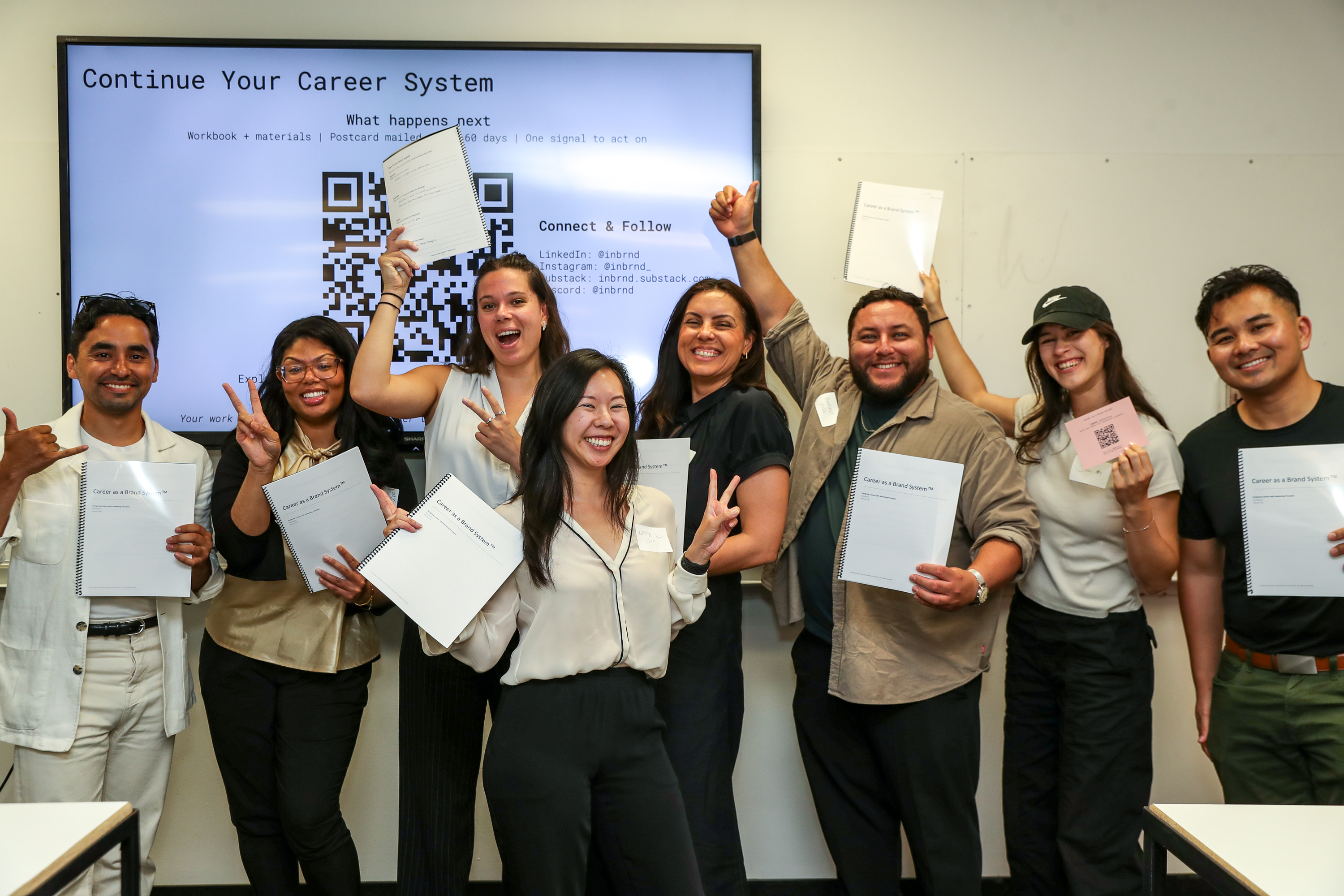 The same group celebrating with playful poses and peace signs after the session