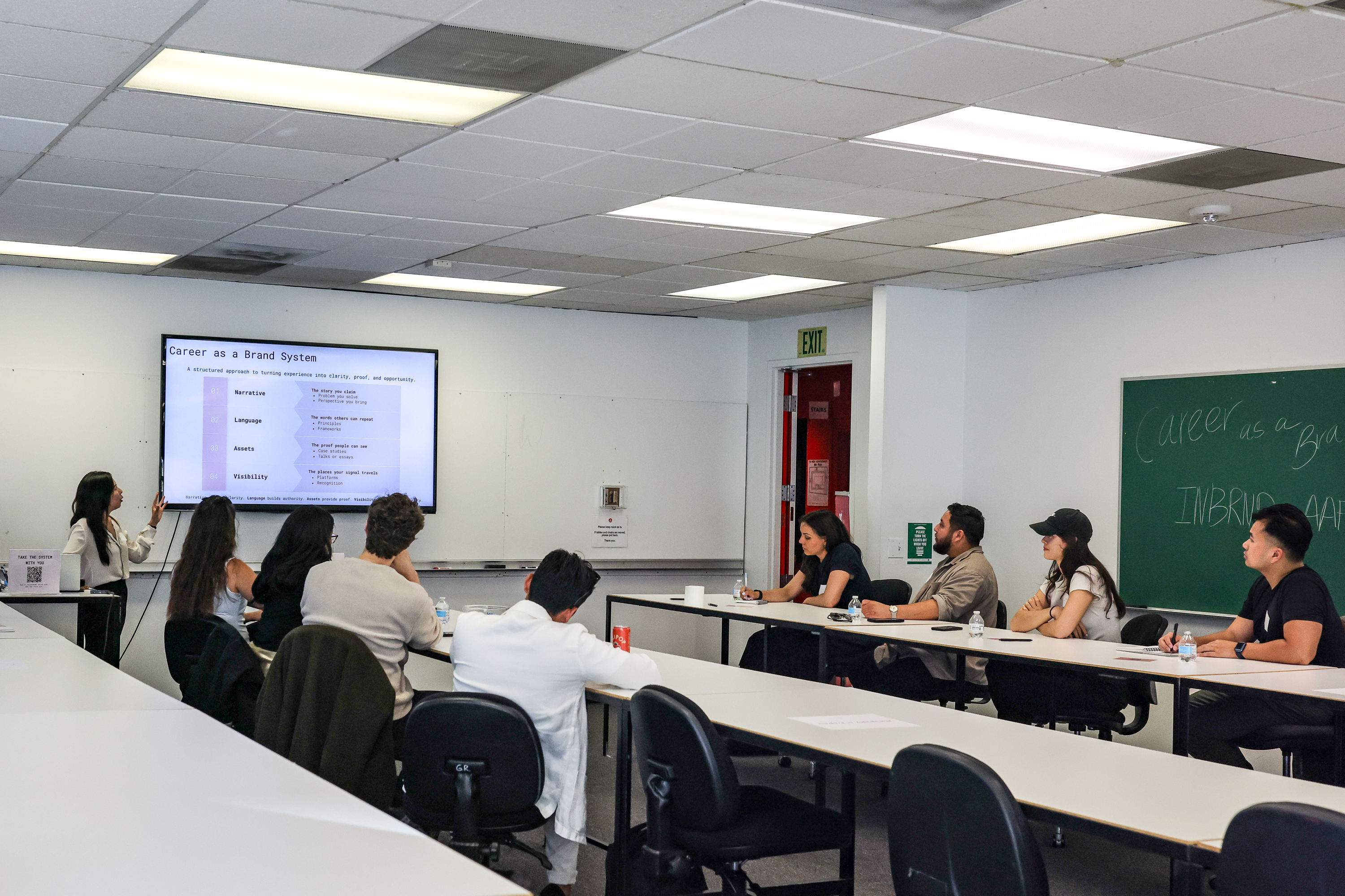 Wide shot of the classroom with participants watching the Career as a Brand System slides