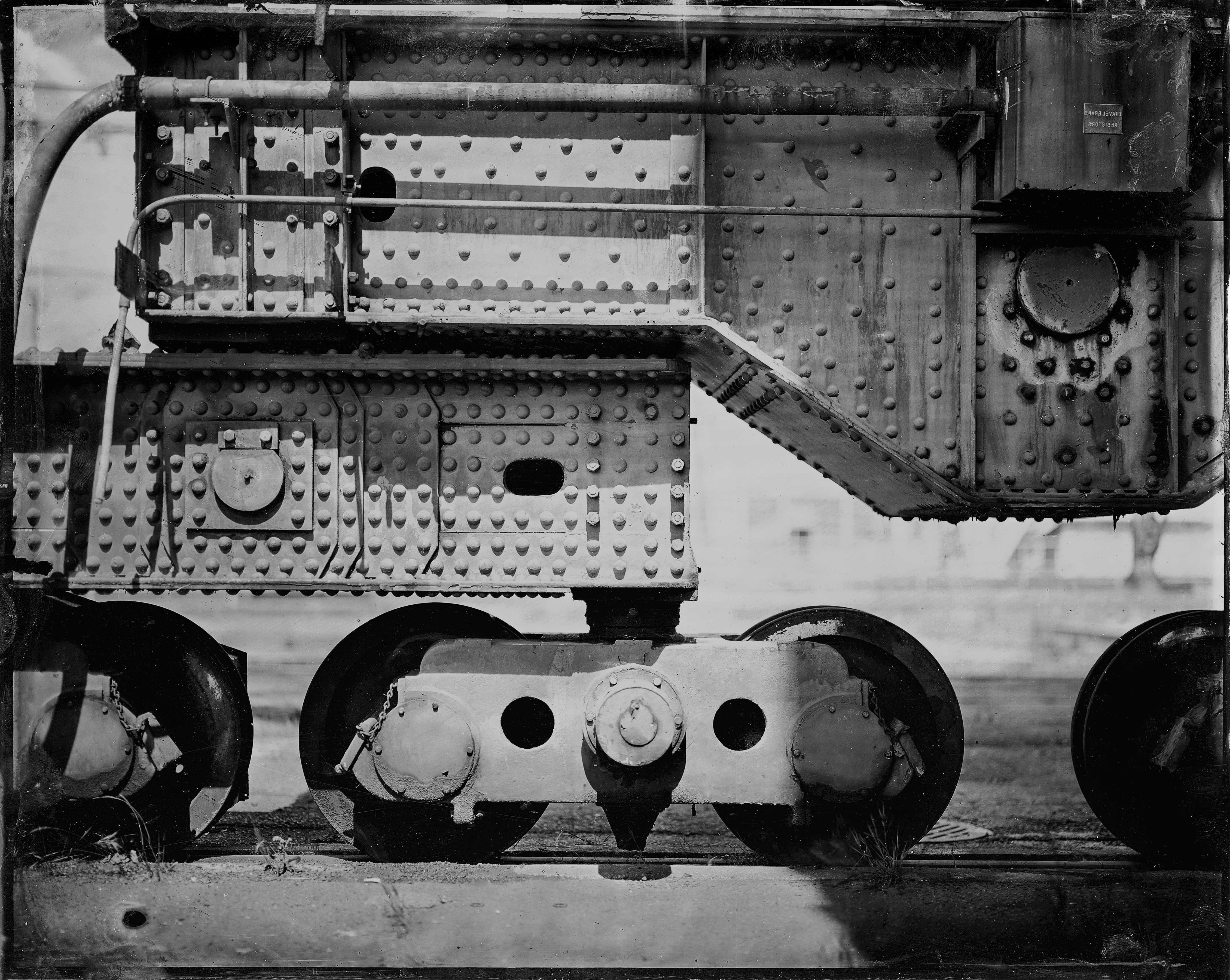Industrial steam locomotive overhead view showing riveted metal construction, boilers, pipes, and mechanical components with geometric precision