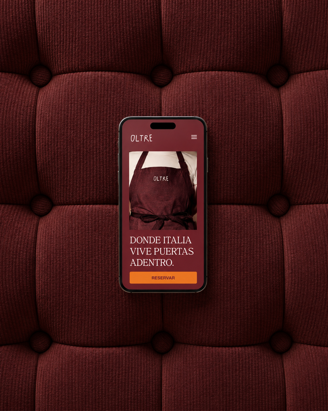 Mockup de la web de Oltre sobre un fondo textil granate.