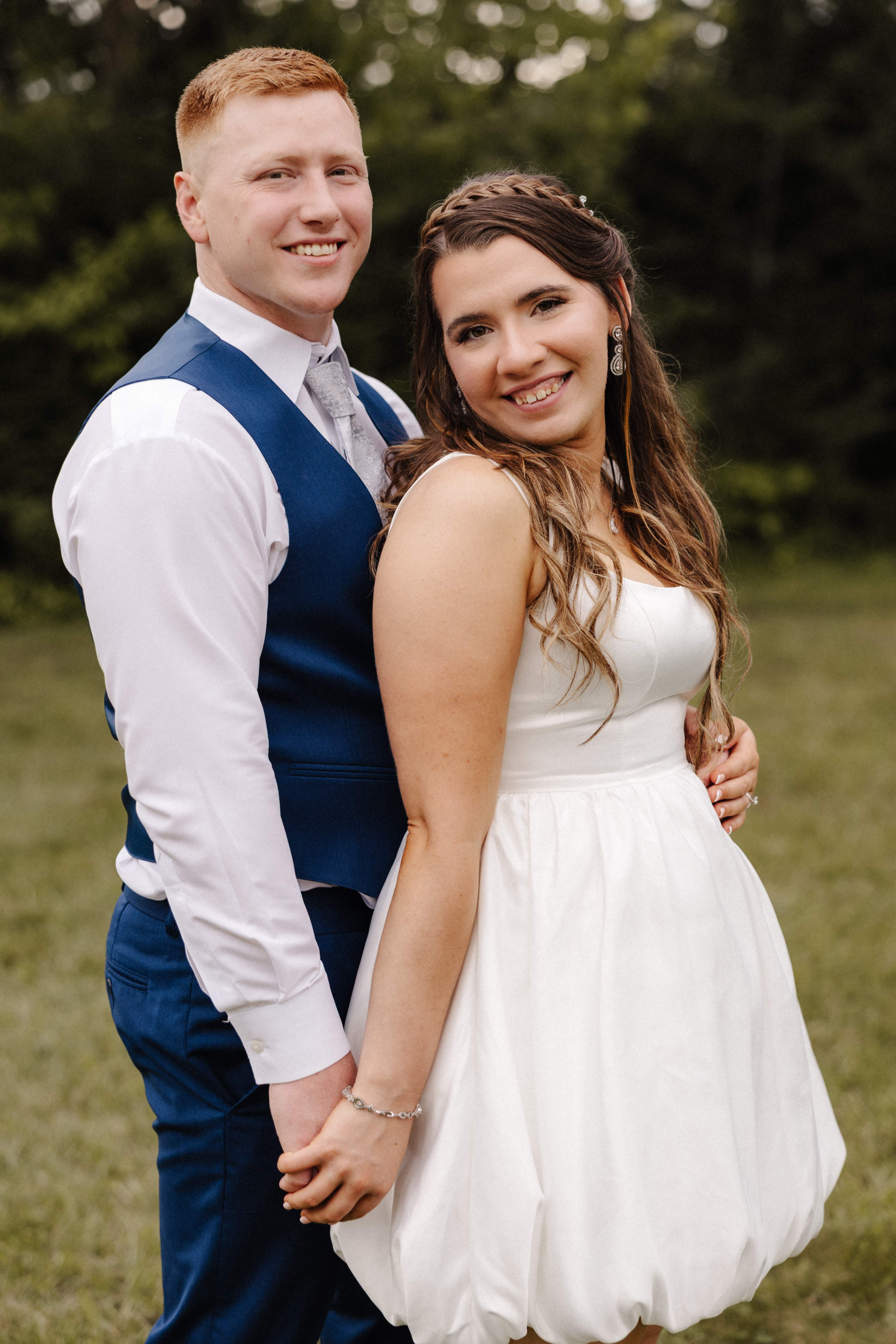 Couple portrait in short reception dress smiling at camera