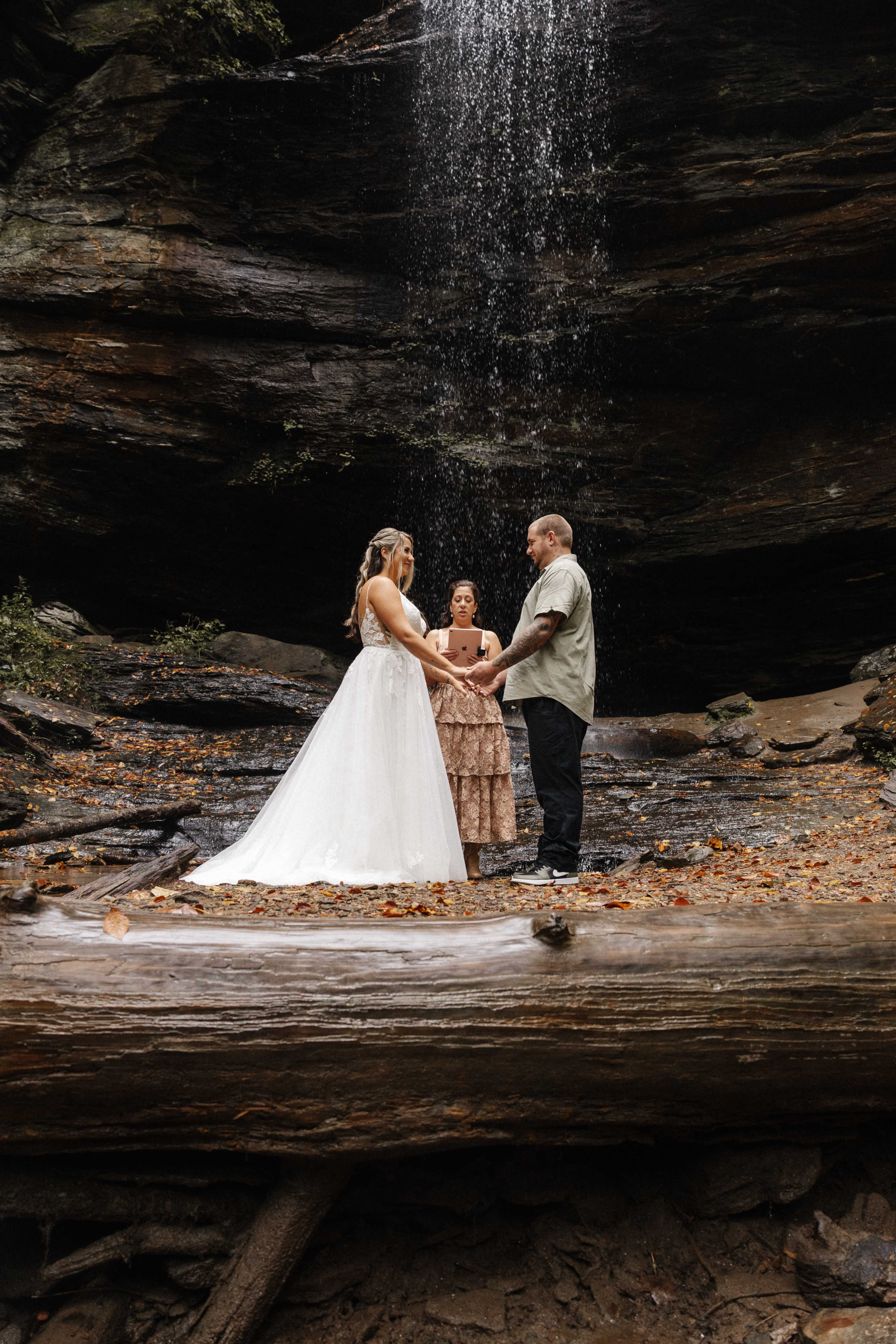Waterfall ceremony with couple exchanging vows on rocks