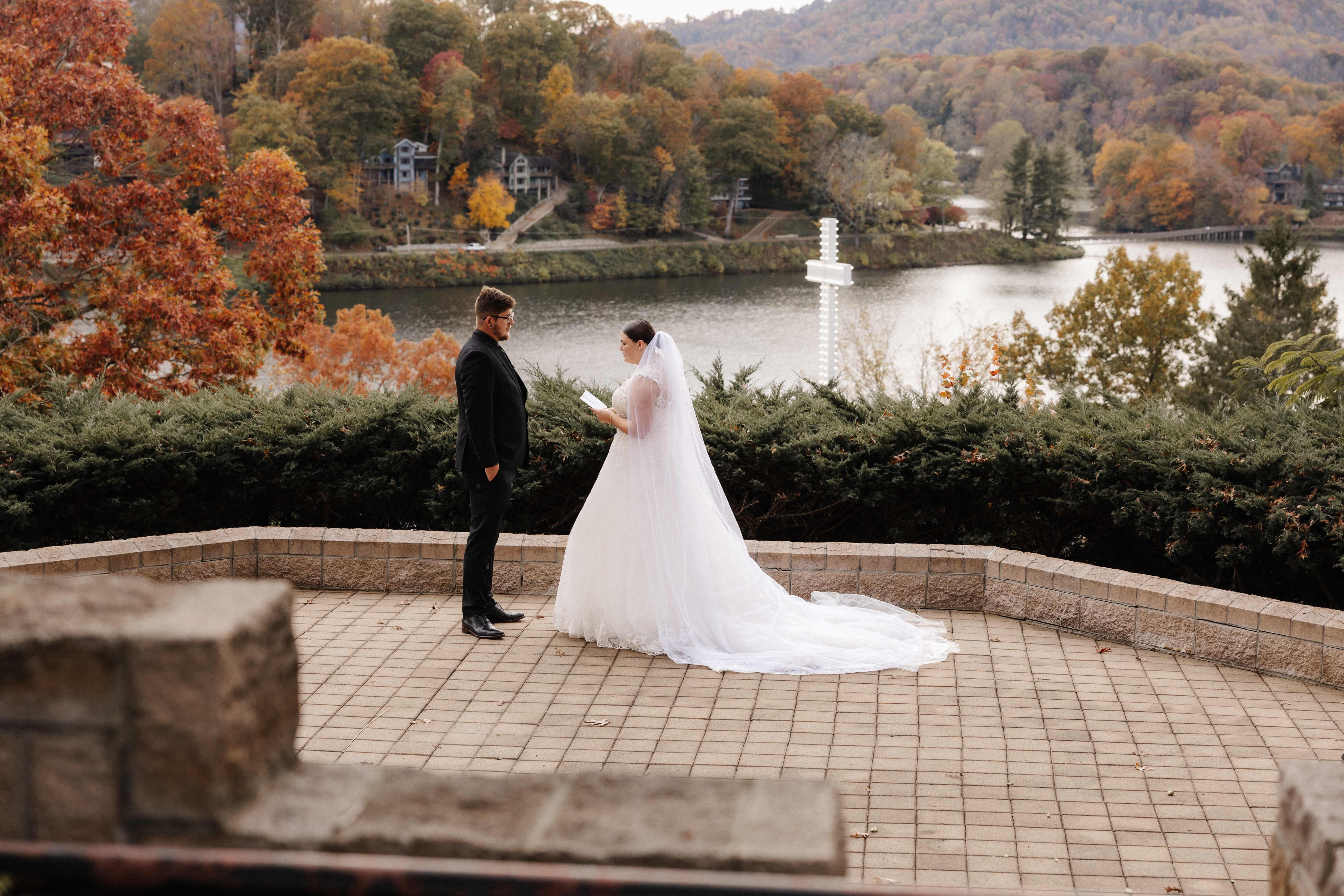 Couple exchanging vows on terrace overlooking fall lake and mountains
