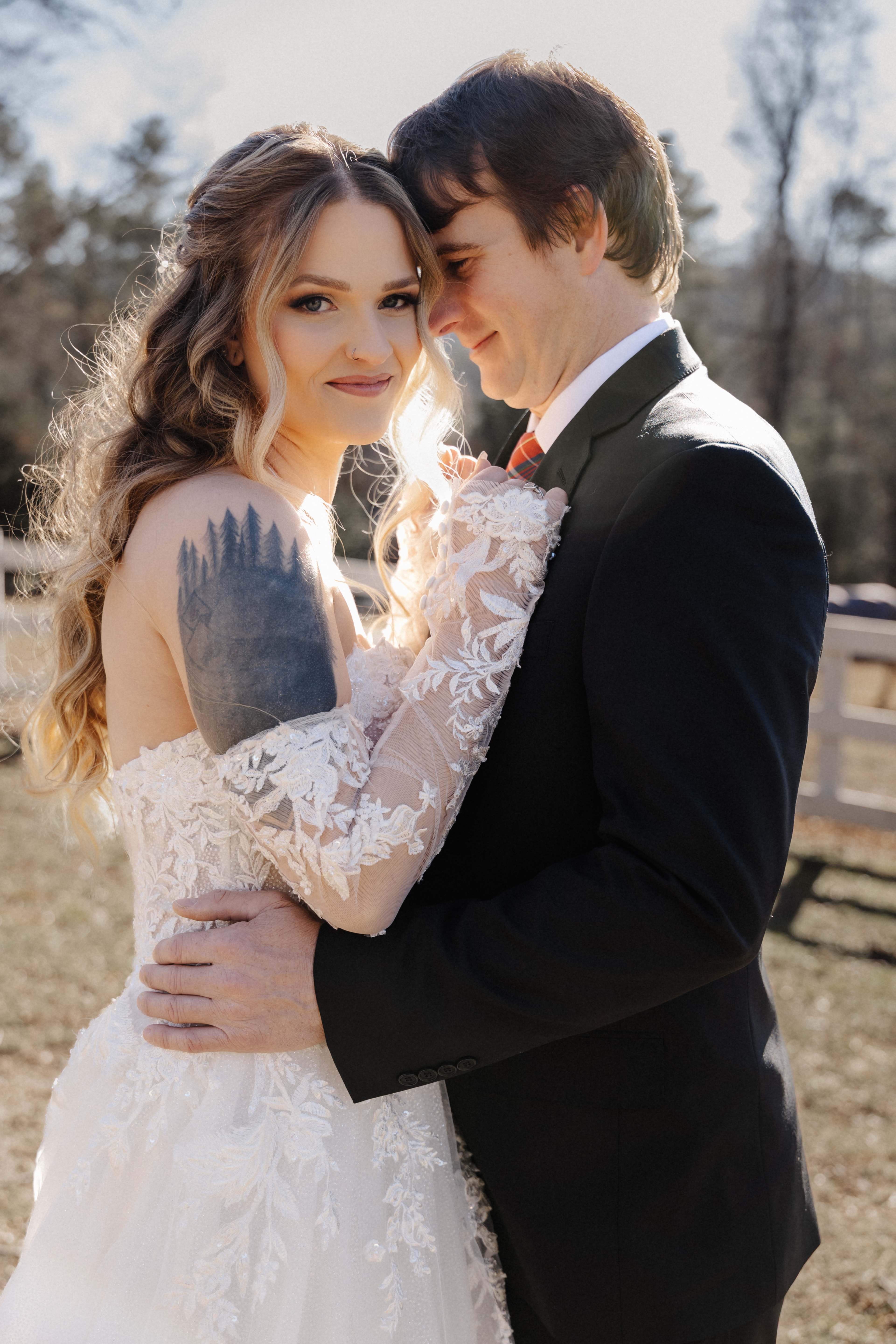 Intimate couple portrait with golden backlight showing bride's tree line tattoo