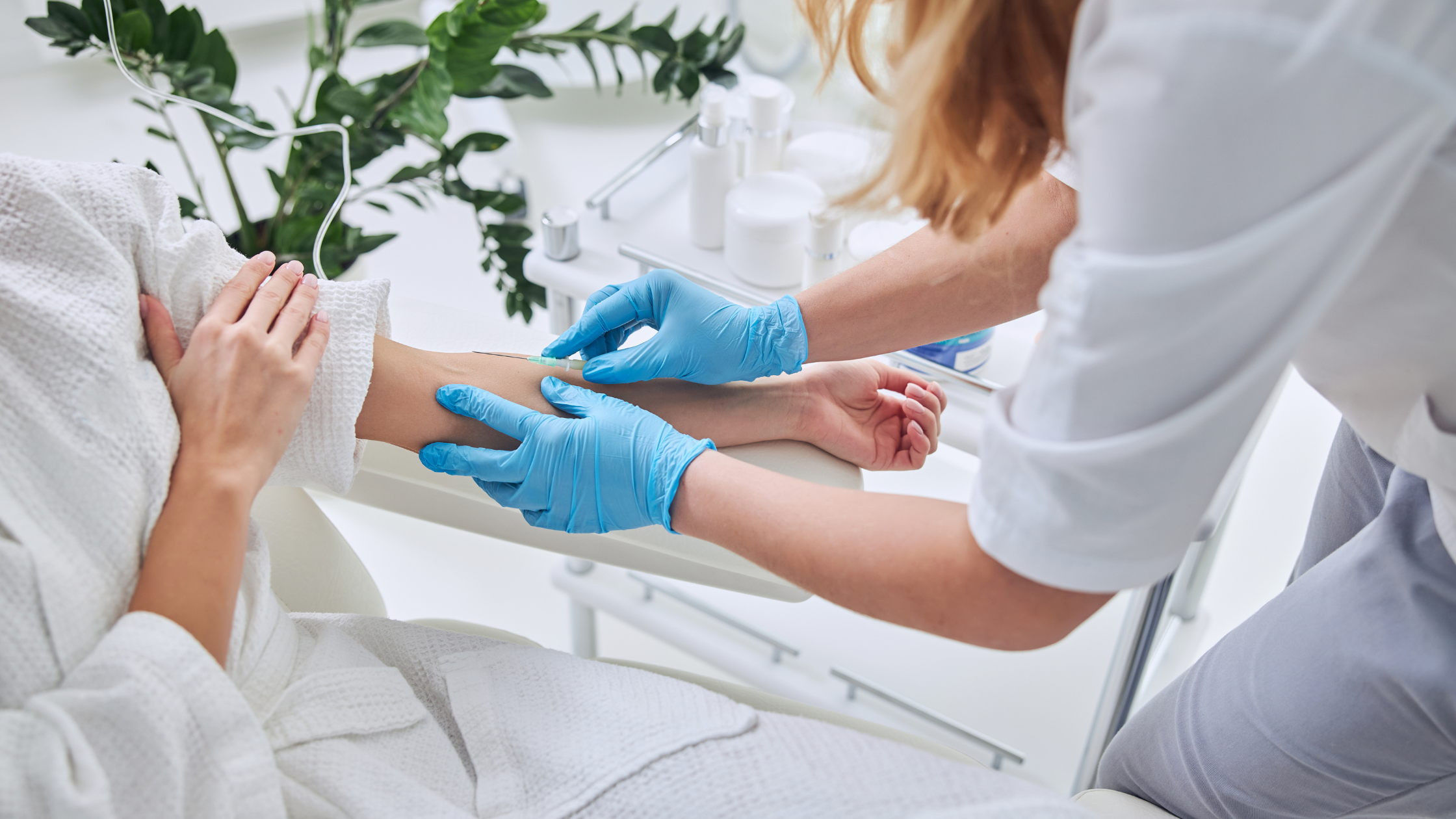 Clinician wearing blue gloves inserting an IV catheter into a relaxed client's arm