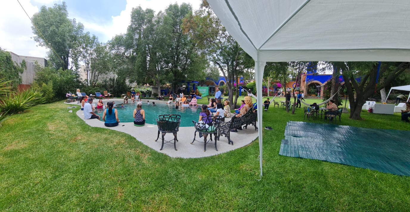 Alberca con carpa y mesas de hierro