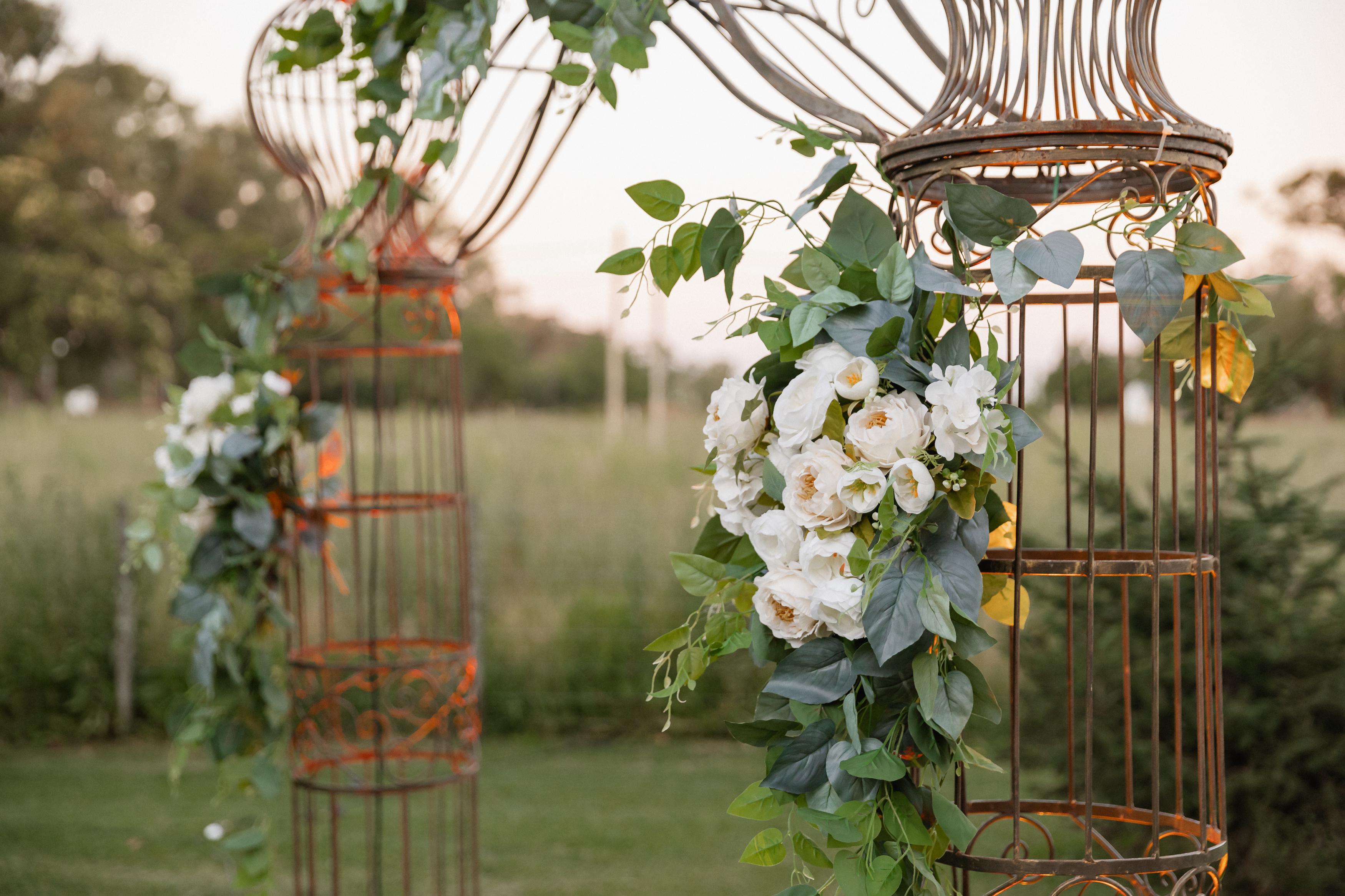 Decoraciones florales elegantes con jaulas de cobre y rosas blancas