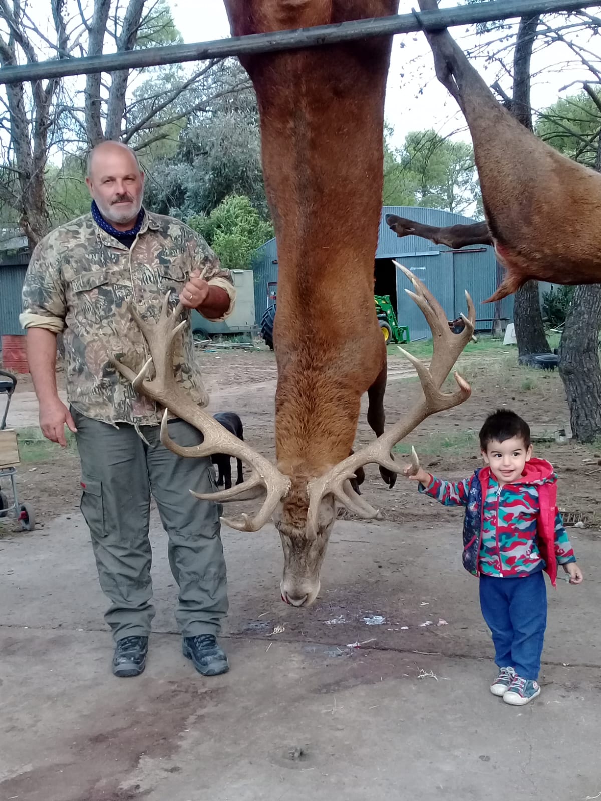 Family hunting experience at Valle Daza - Adult and child with harvested deer