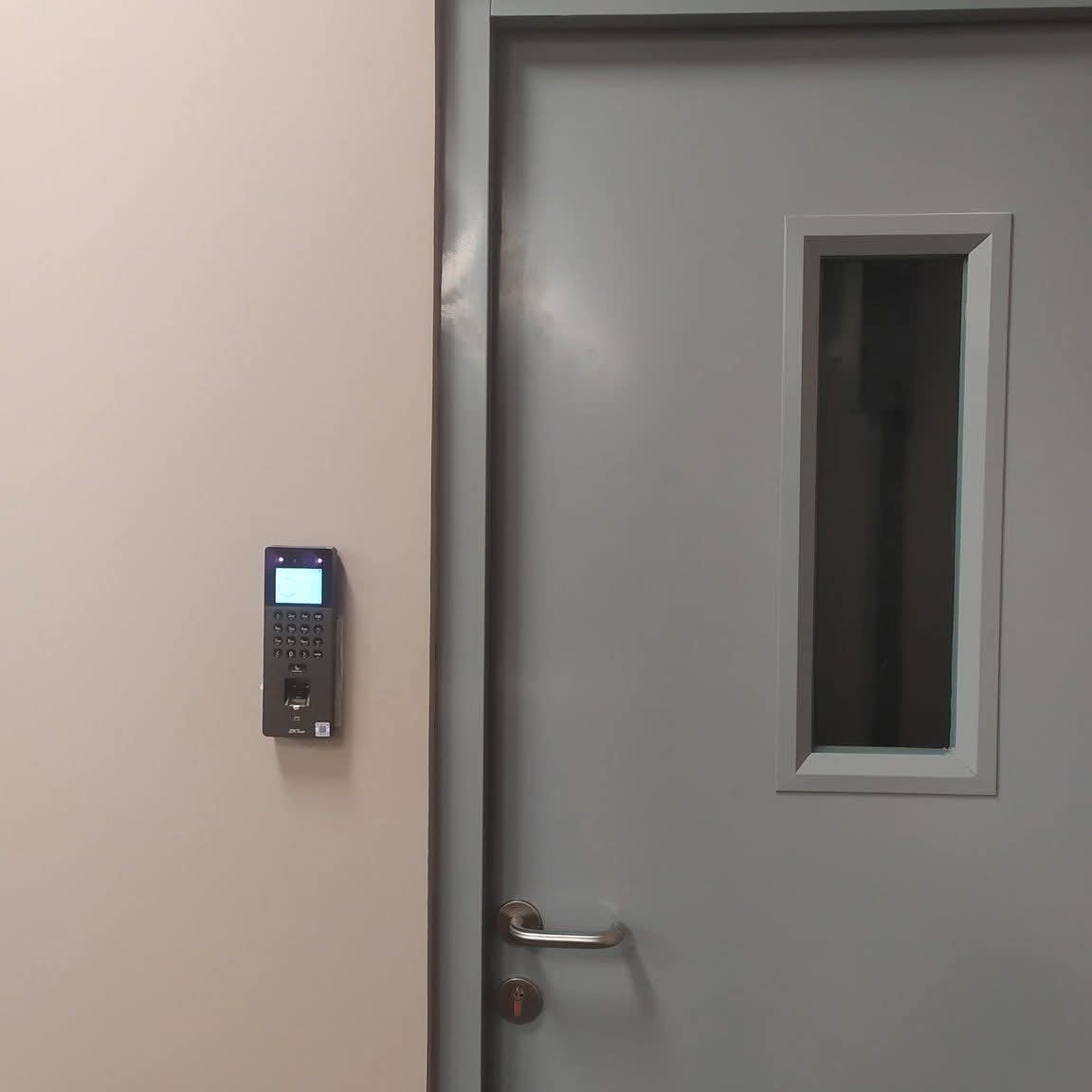 Terminal de contrôle d'accès biométrique installé à côté d'une porte de bureau