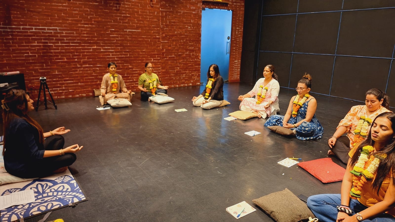 Meditation workshop with participants wearing flower garlands