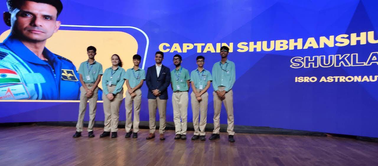 Akshat with a school team on stage