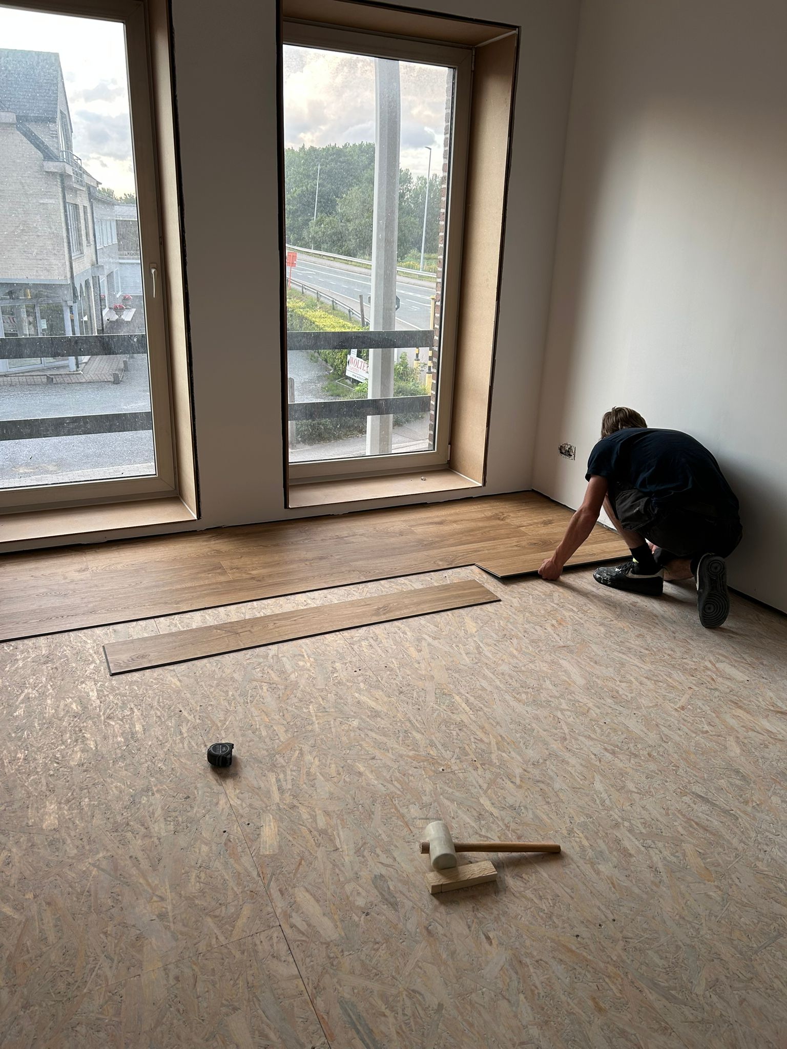 Vakman legt laminaatvloer in afgewerkte ruimte