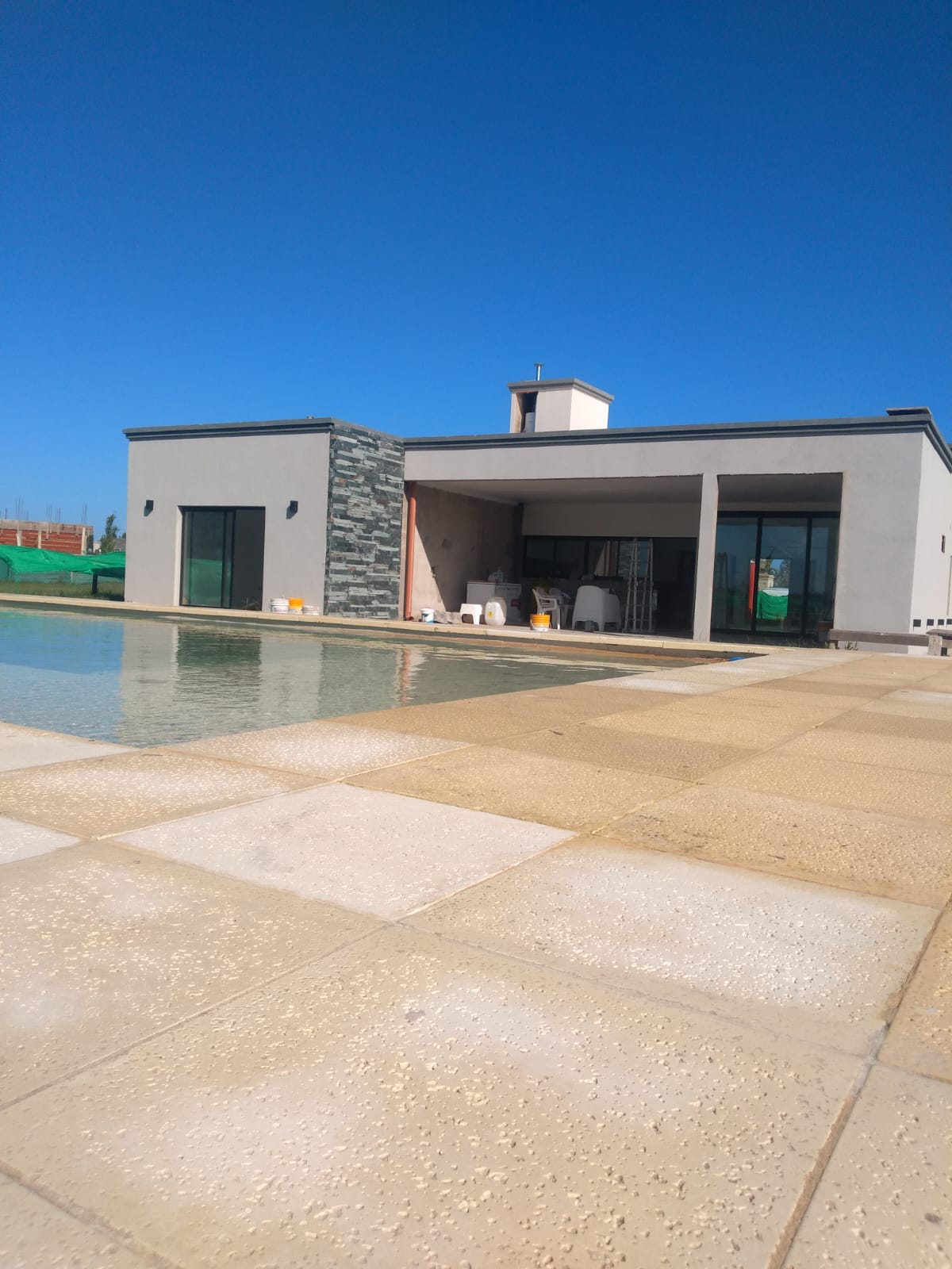 Contrafrente con pileta llena, solado perimetral y galeria con columna de piedra laja