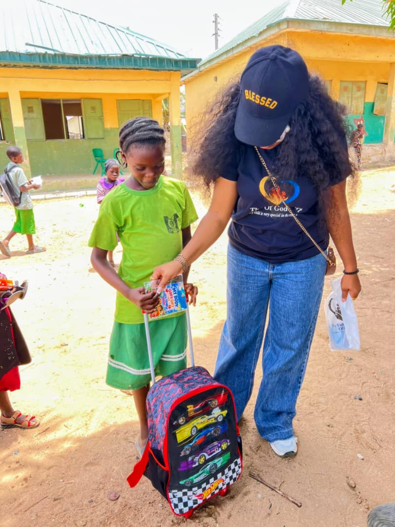 Woman giving backpack to child at community center