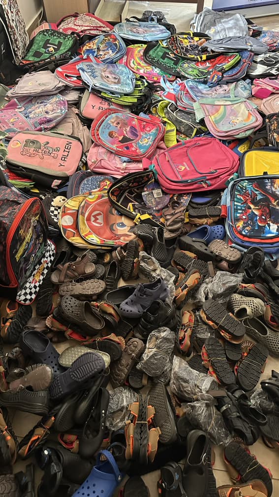 Colorful backpacks and shoes collected for distribution