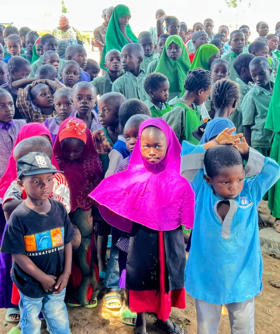 Large group of children in colorful clothing at community event