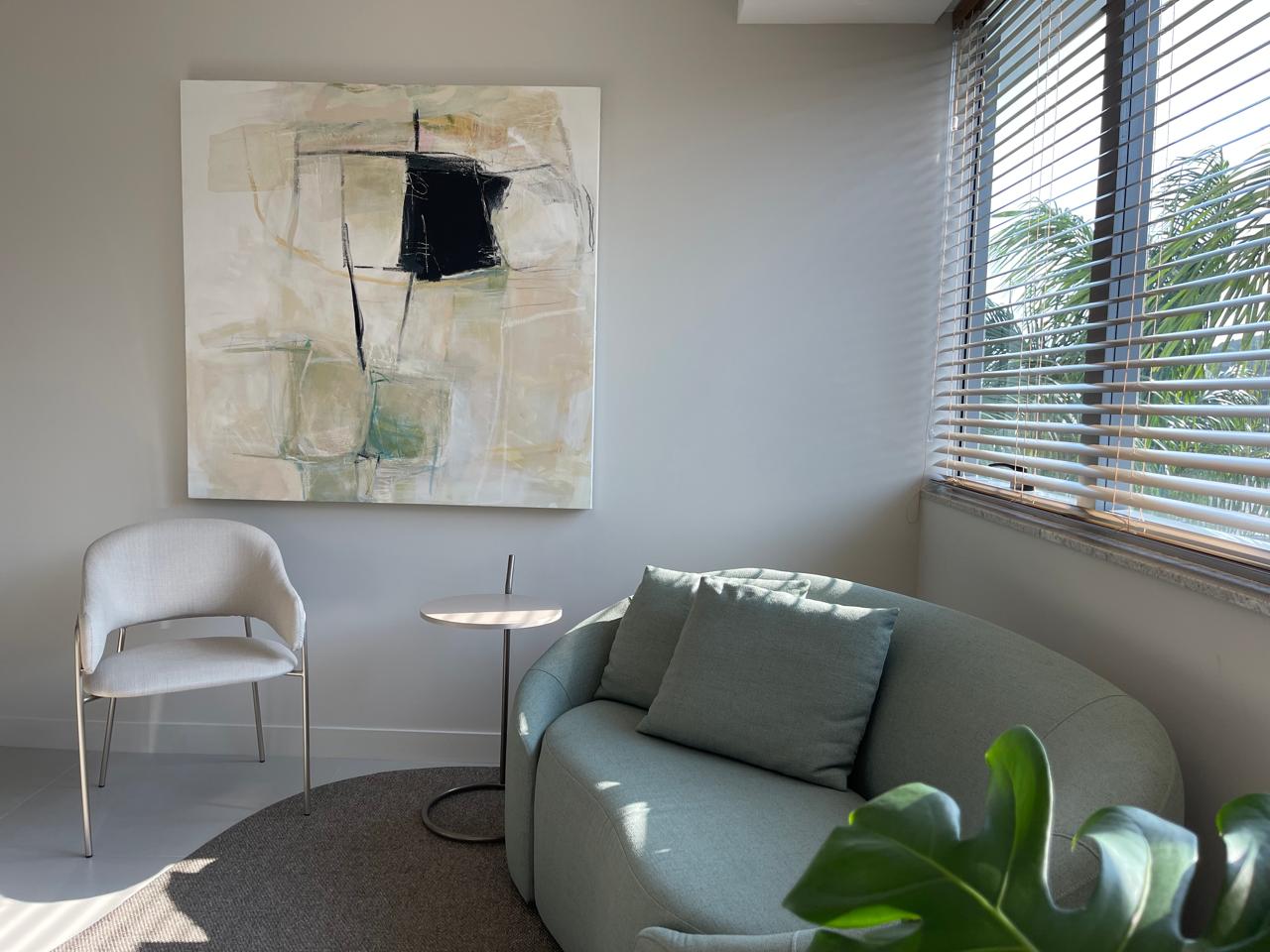 Sala de atendimento com sofá curvo verde-sálvia