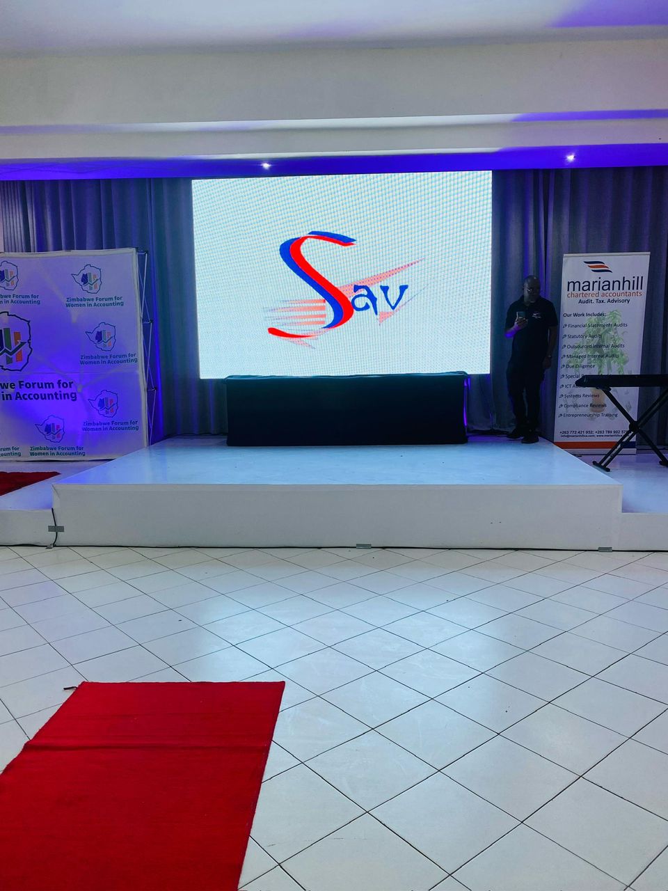 Professional corporate stage with Sunvalley Audio Visual LED display, blue ambient lighting, red carpet