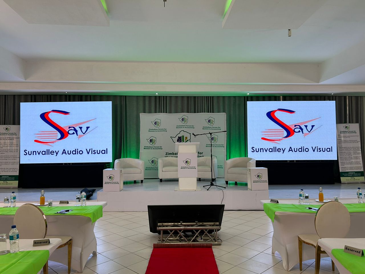 Conference stage with green LED neon truss, Sunvalley branding, professional setup