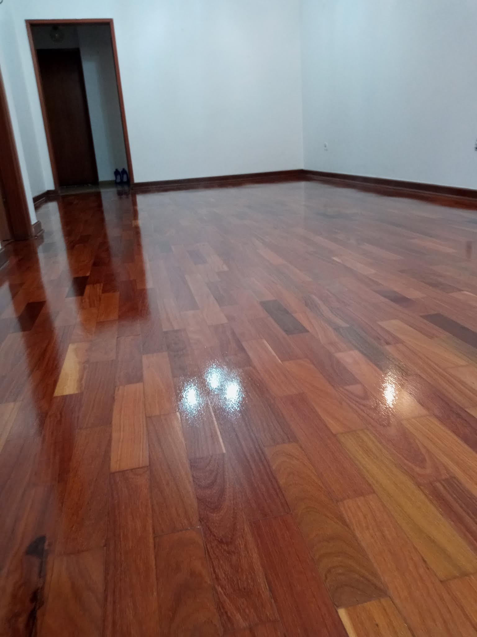 Quarto com piso de madeira avermelhado polido