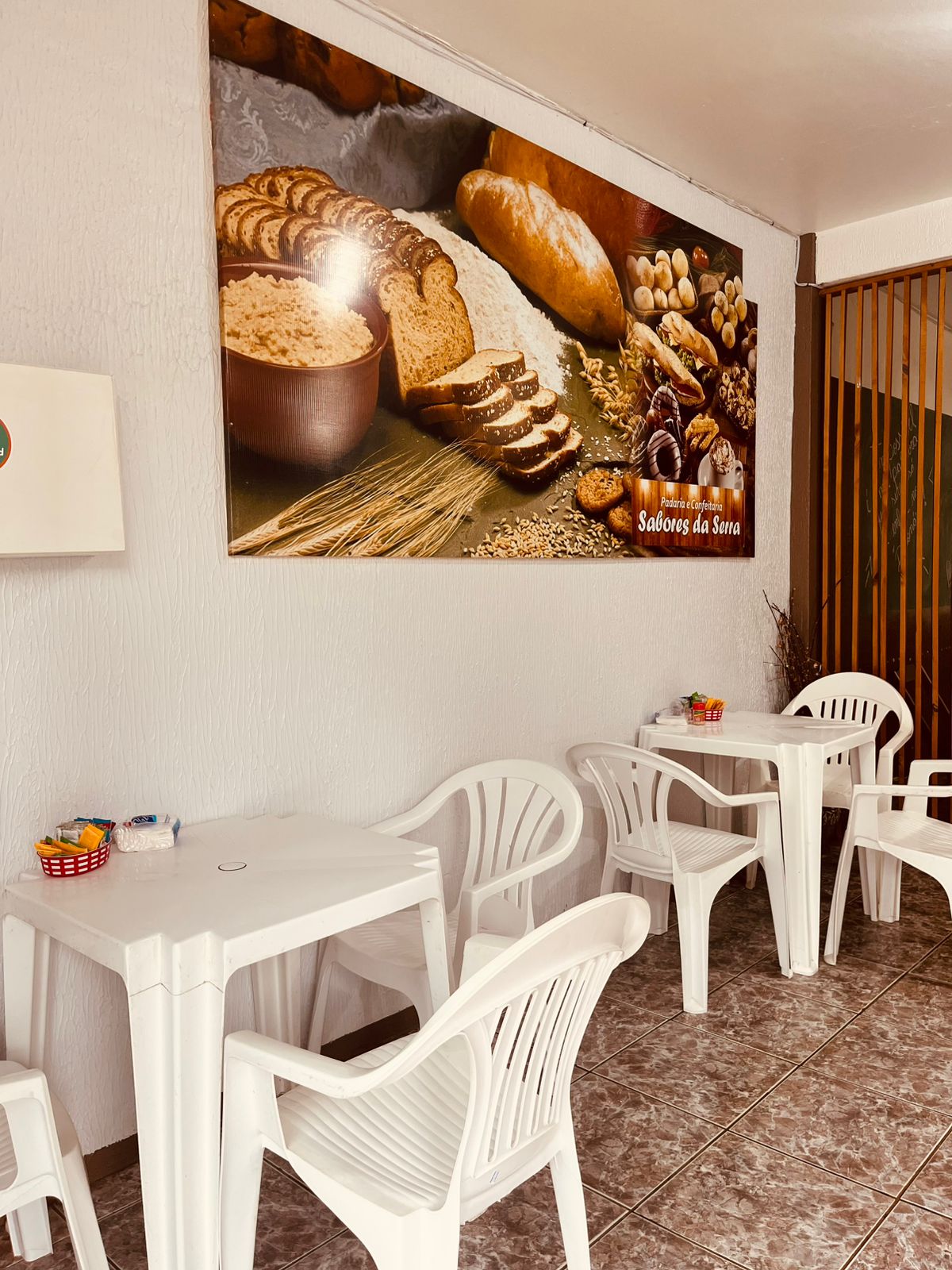 Salao alternativo com mesas brancas e quadro na parede