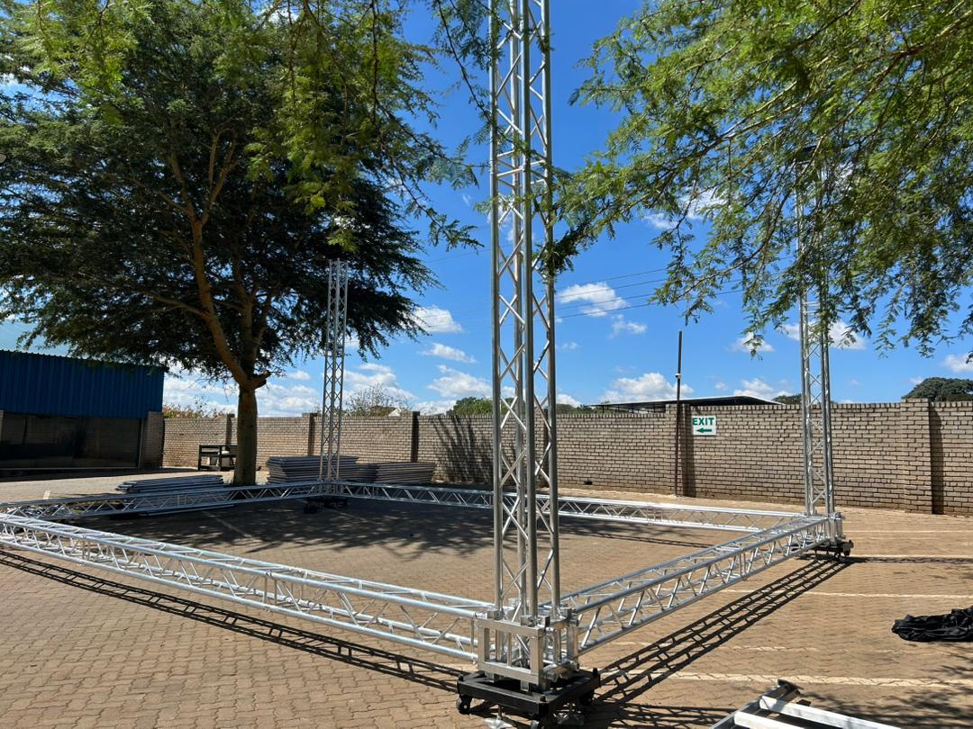 Outdoor stage with white metal truss structure, professional aluminum construction, scenic backdrop