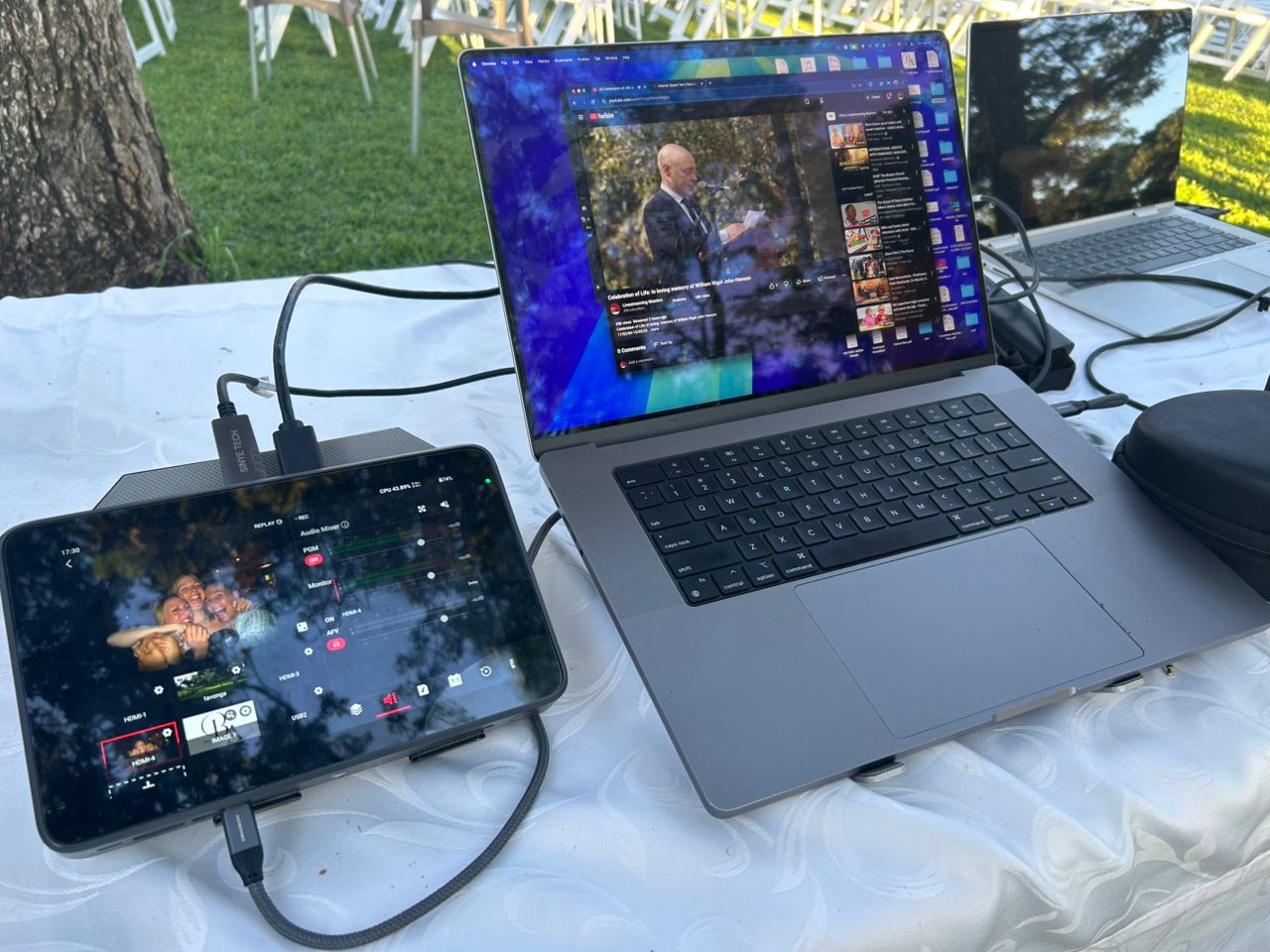 Professional live streaming and video production setup with laptop and mobile device displaying real-time broadcast