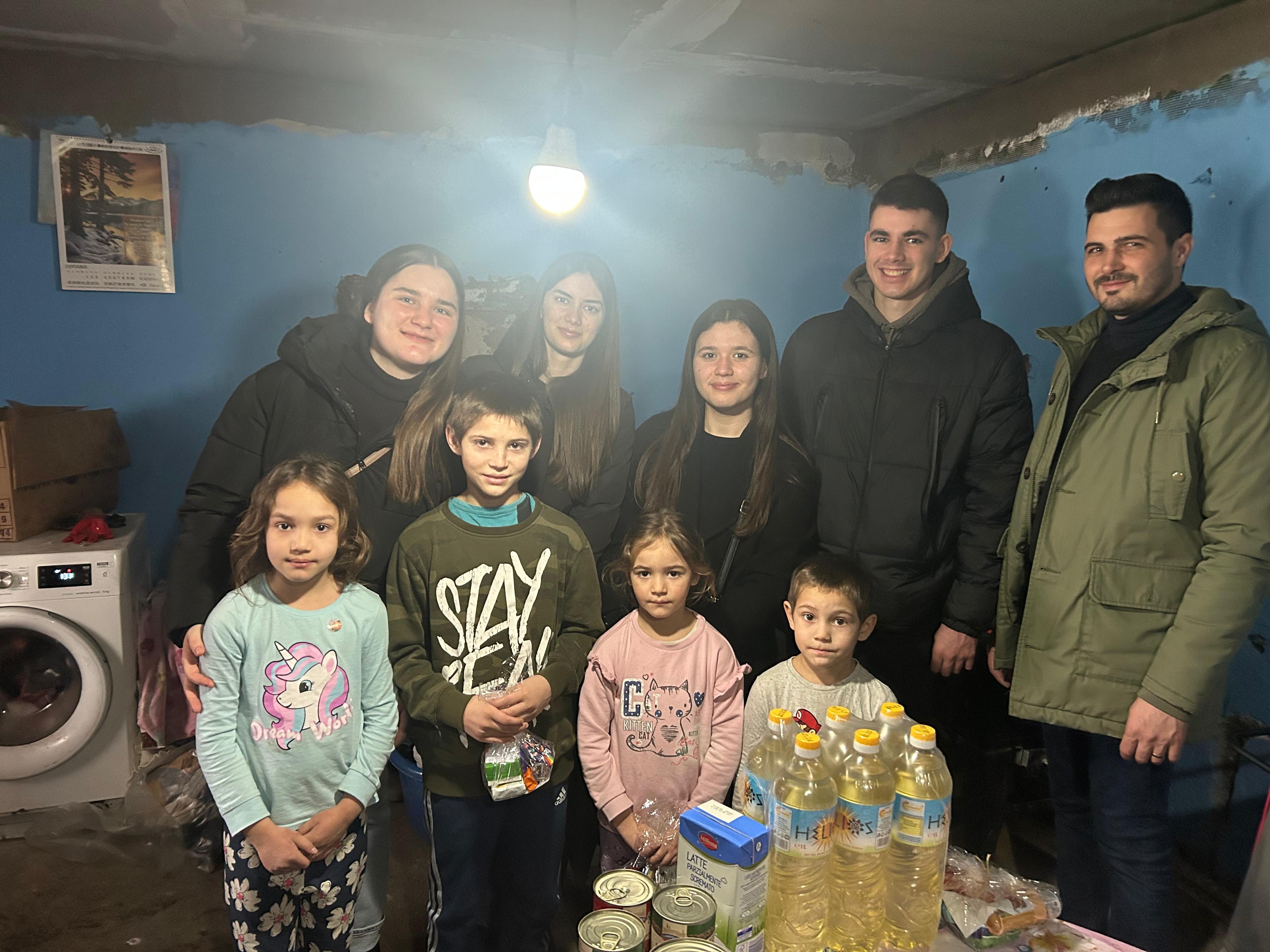 Voluntari și copii în cameră cu alimente