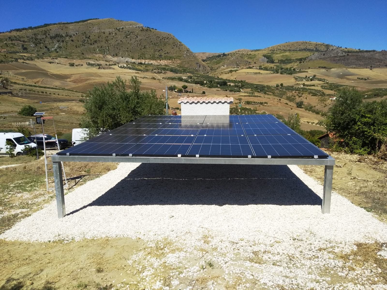 Impianto fotovoltaico a terra su struttura metallica in campagna con colline