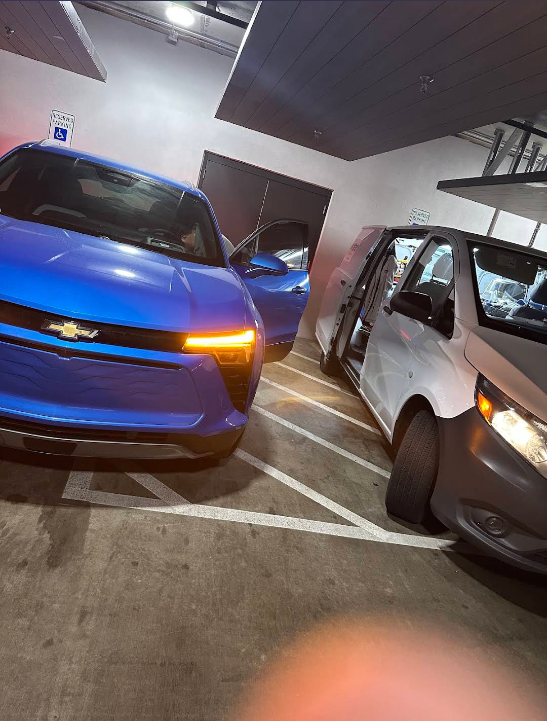 Mobile locksmith service van with Chevrolet vehicle in parking garage