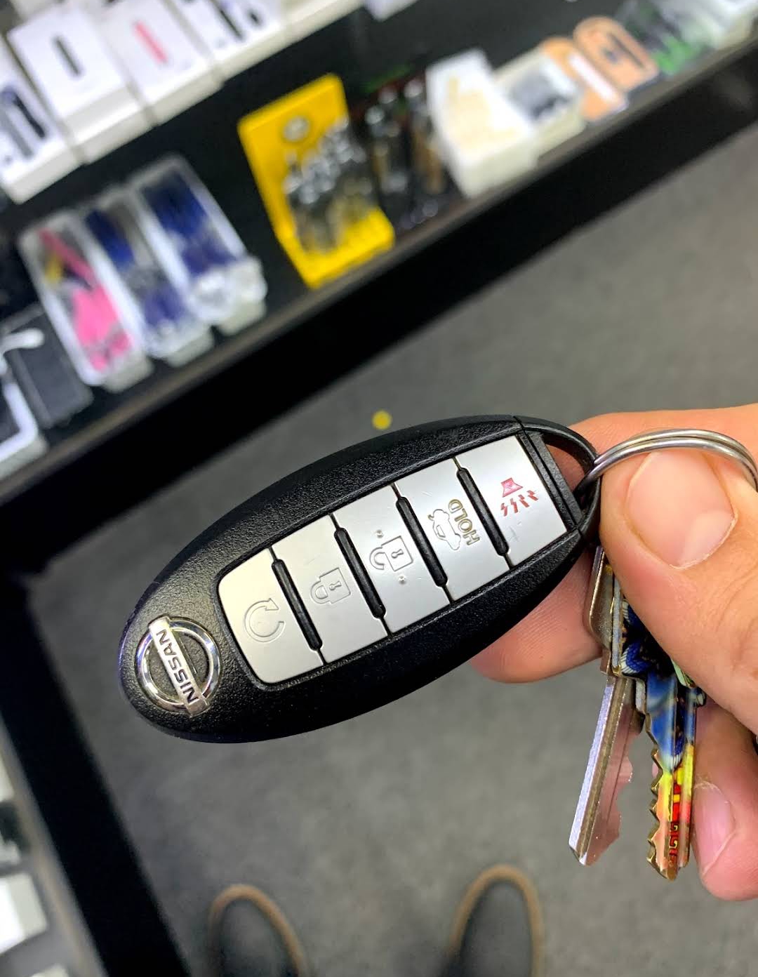 Nissan Intelligent Key smart key fob with key stock inventory in background