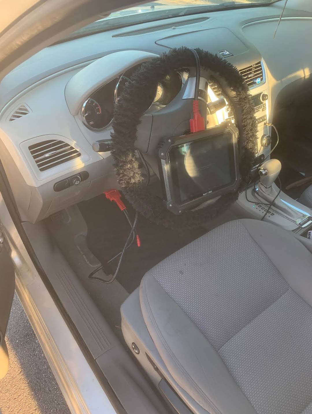 Autel key programming tablet connected to vehicle OBD port during transponder programming