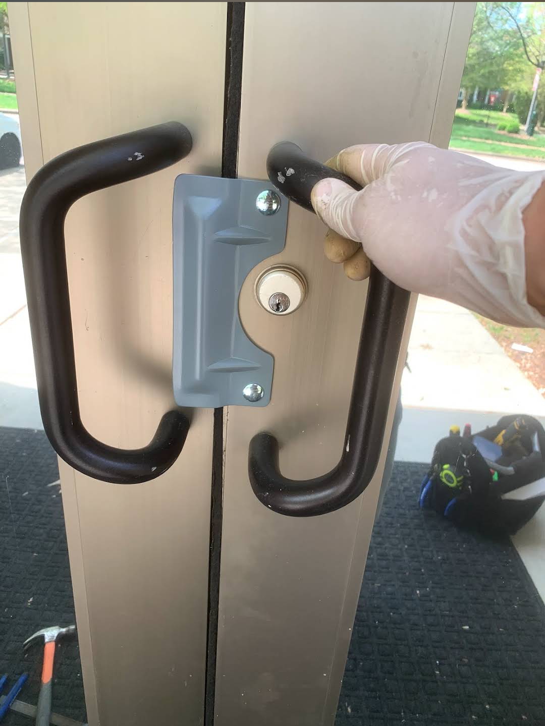 Commercial door lock installation with protective gloves