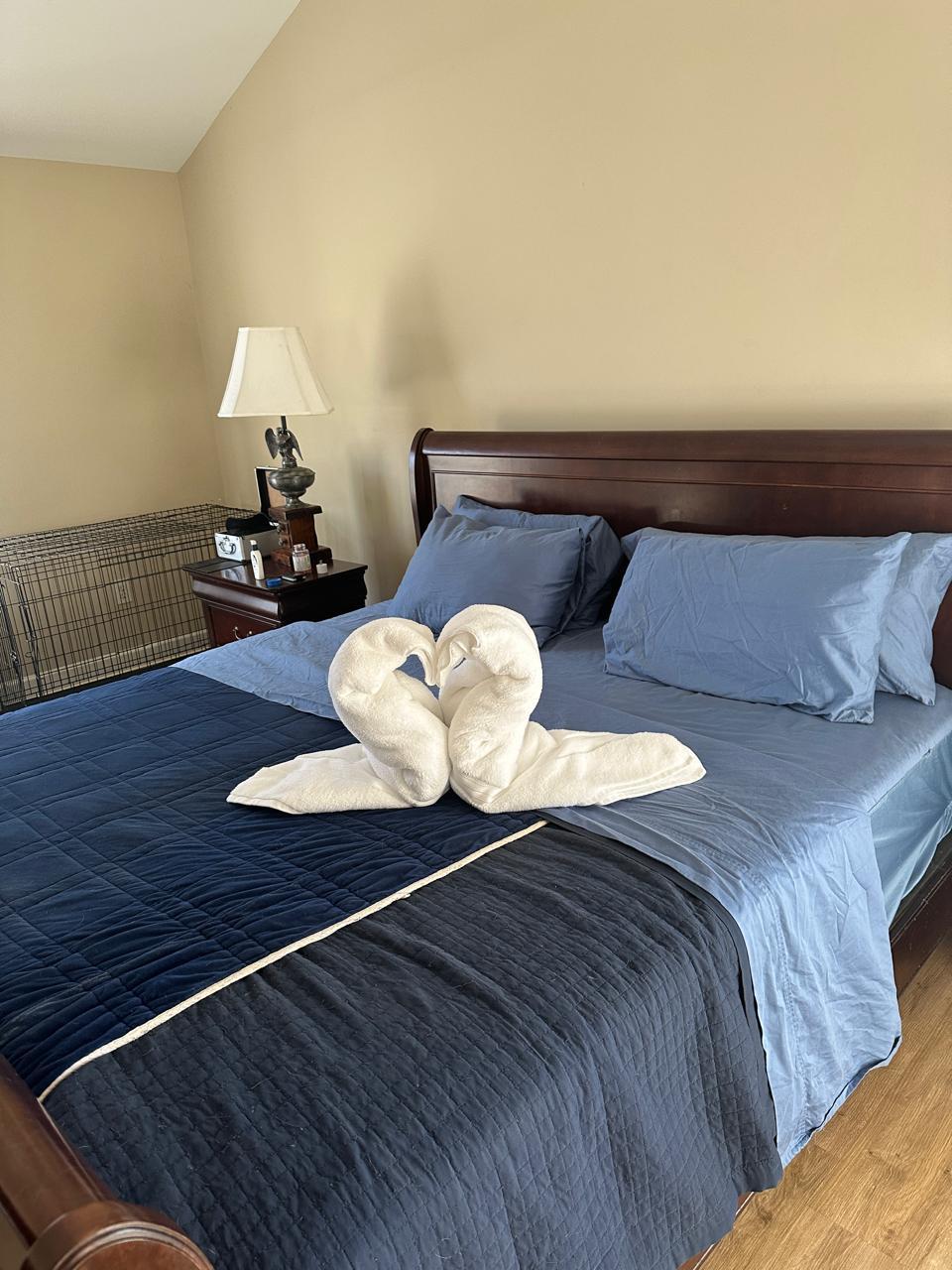 Beautifully made bed with decorative towel swans
