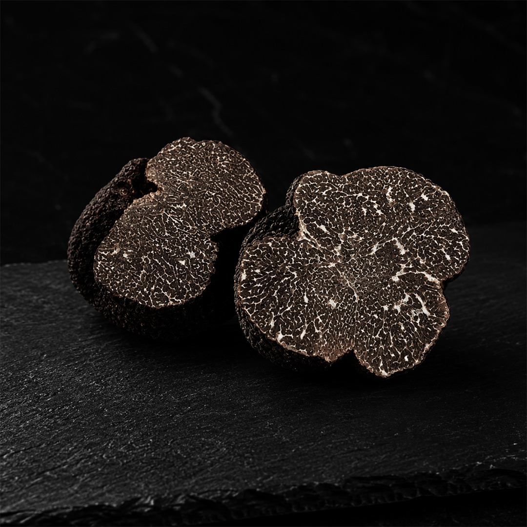 Two halved black truffles showing dark marble interior