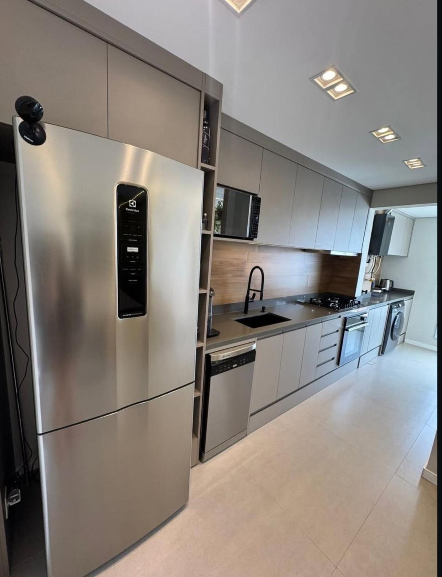 Cozinha moderna com armários cinza e geladeira inox