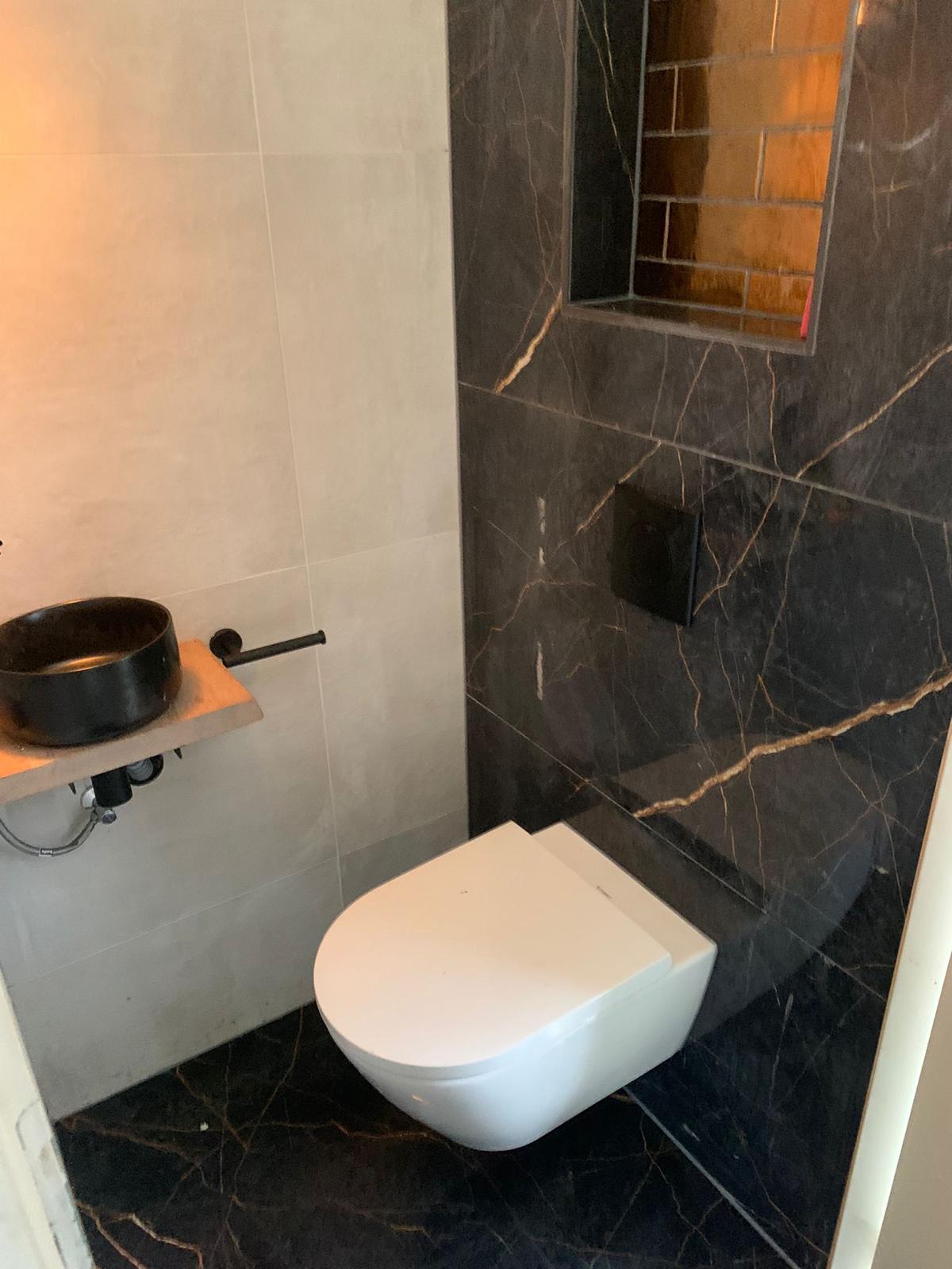 Toilet met zwart marmer tegels met gouden ader
