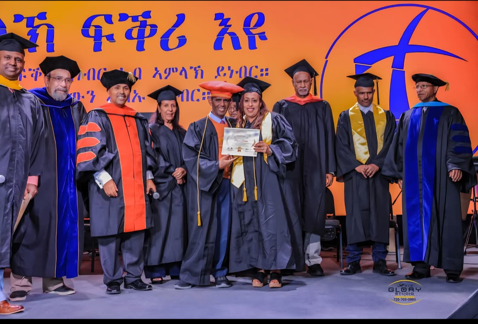 Faculty and Graduates with Cross Backdrop — Denver