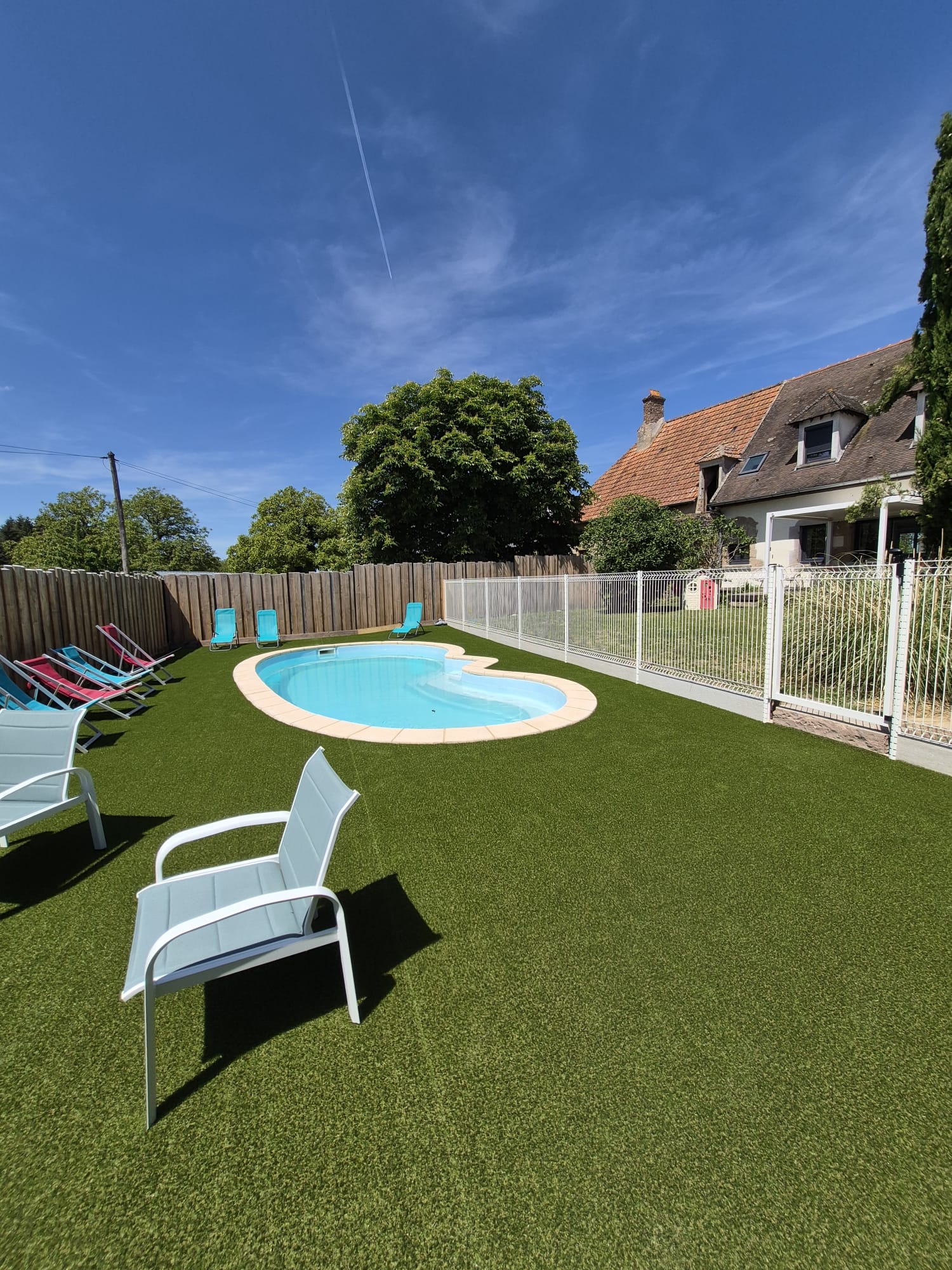 Vue de la piscine avec maison en arriere-plan