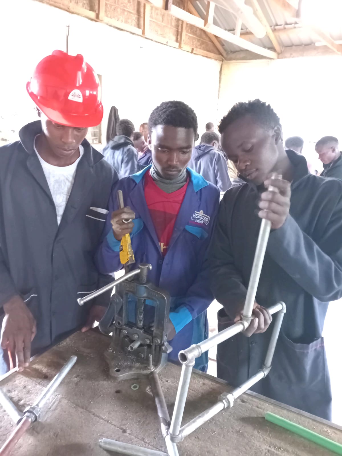 Metal work and welding students with tools