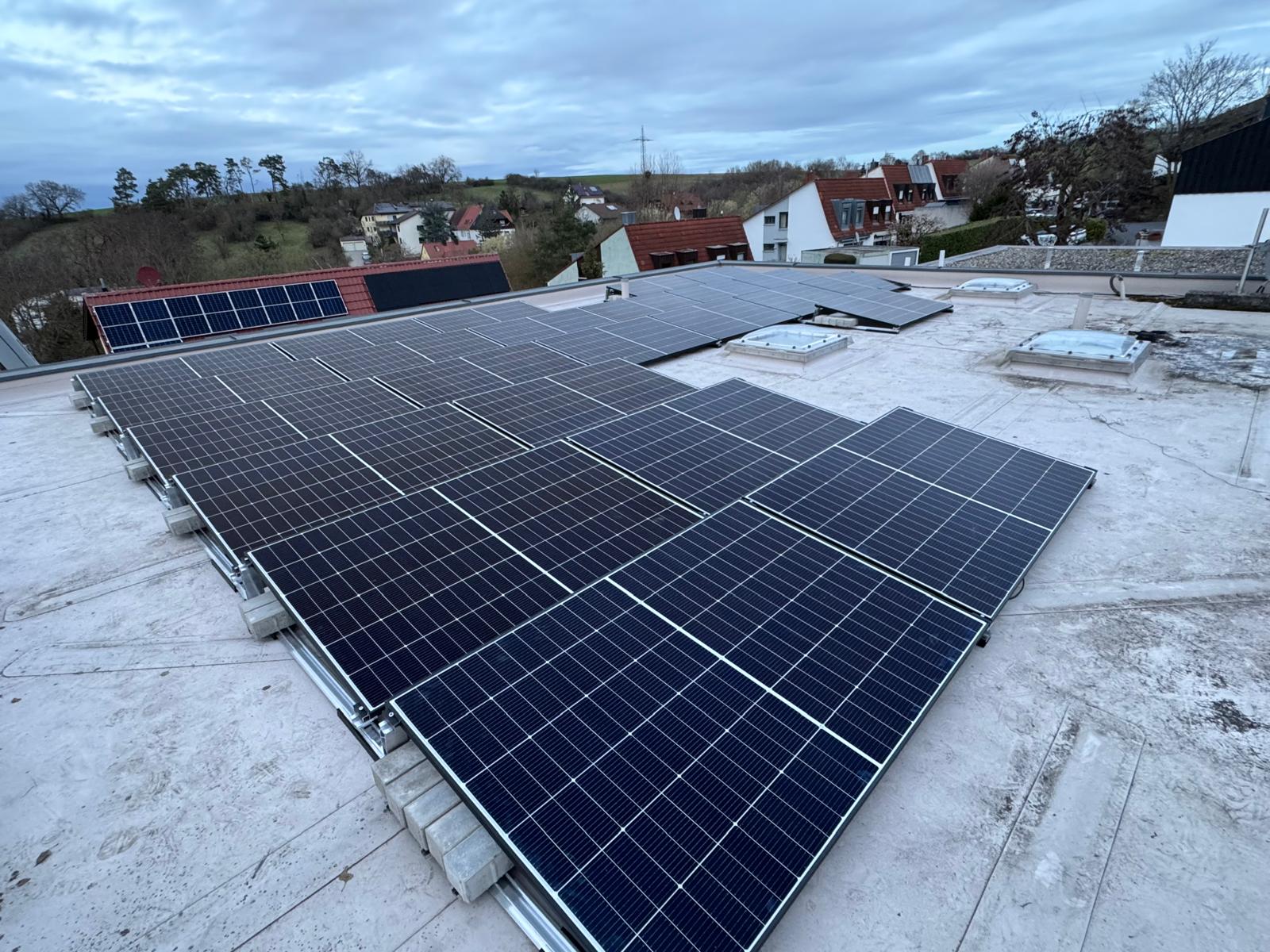 Flachdach-Solaranlage mit Dorfpanorama