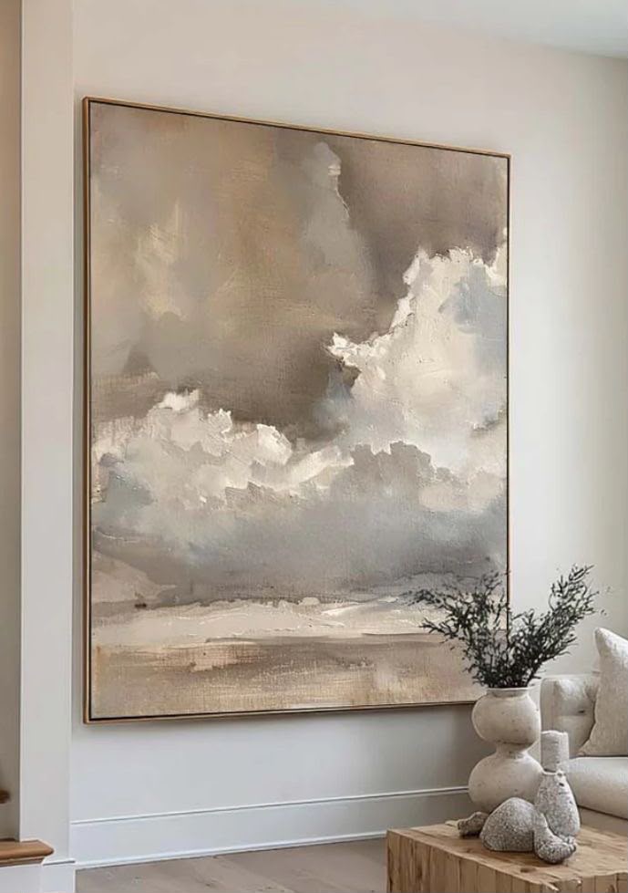 Dramatic storm clouds in warm gray and cream tones over sandy earth horizon